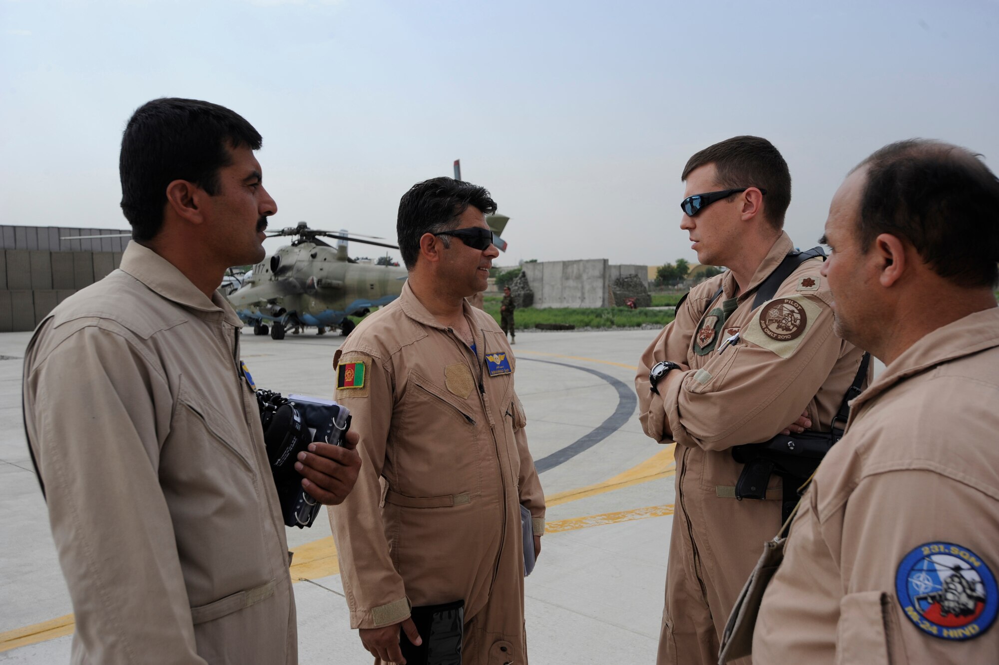 U.S. Air Force Maj. Caleb Nimmo, Mi-35 team lead assigned to the 440th Air Expeditionary Advisor Squadron, back right, speaks with Afghan National Army Air Corps Mi-35 Hind E helicopter aircrews prior to their take-off for a live-fire training mission over the Forward Operating Base Shank firing range May 16, 2010, at Kabul International Airport, Afghanistan. (U.S. Air Force photo/ Staff Sgt. Manuel J. Martinez/released)