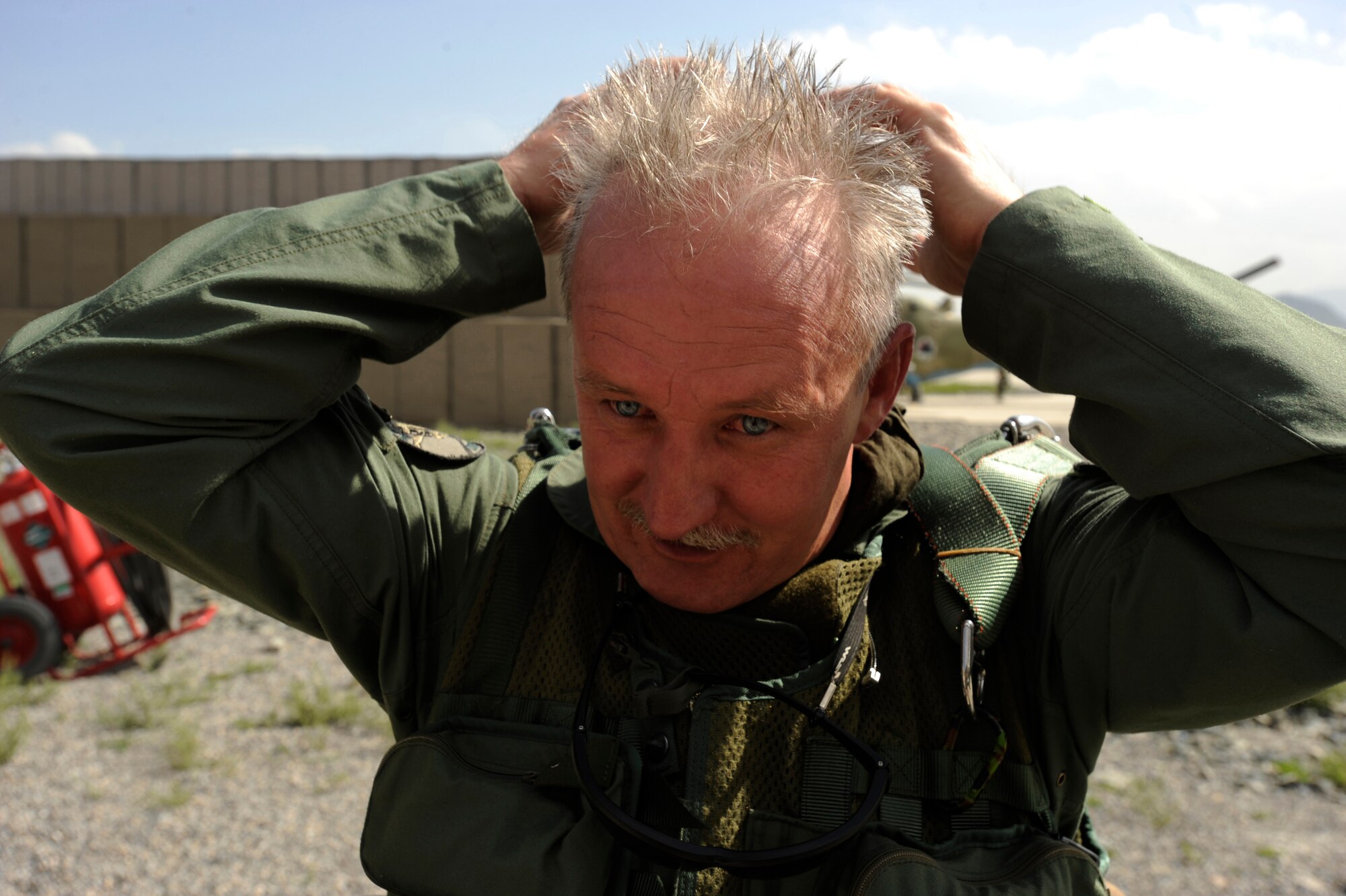Hungarian Air Force Maj. Szili ''Alex'' Sandor, an Mi-35 Hind instructor pilot assigned to the Hungarian Operational Mentoring Liaison Team, grooms his hair after removing his flight helmet upon his return from a live-fire training mission May 11, 2010, at Kabul International Airport, Afghanistan. (U.S. Air Force photo/ Staff Sgt. Manuel J. Martinez/released)
