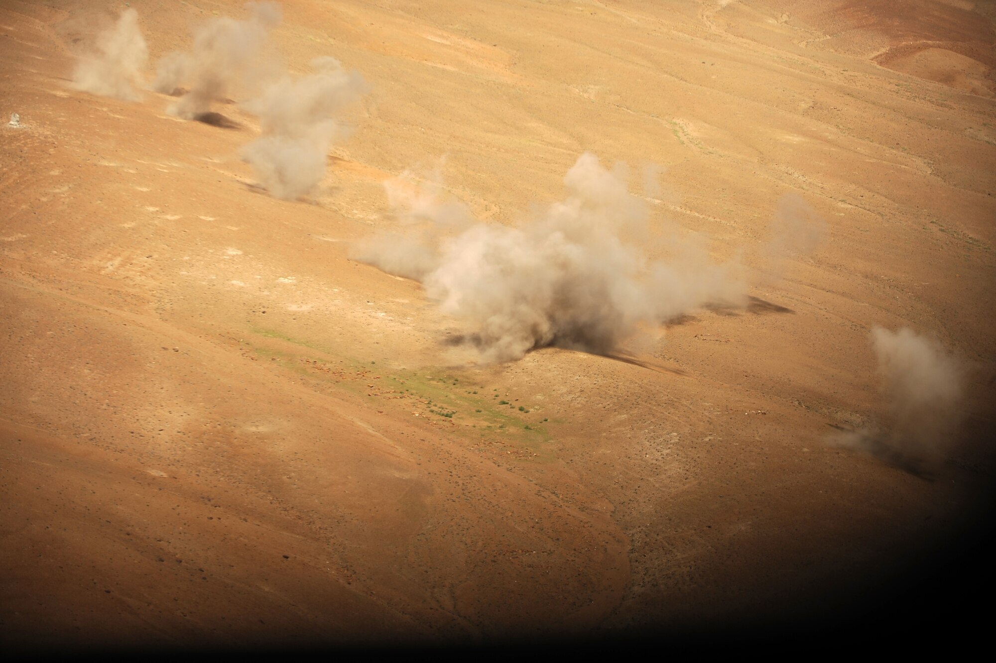 Dust rises from the impact points of KP long-guided rockets fired from an Afghan Mi-35 HIND during a live-fire training mission, May 11, 2010, over Forward Operating Base Shank firing range, Afghanistan. (U.S. Air Force photo/ Staff Sgt. Manuel J. Martinez/released)
