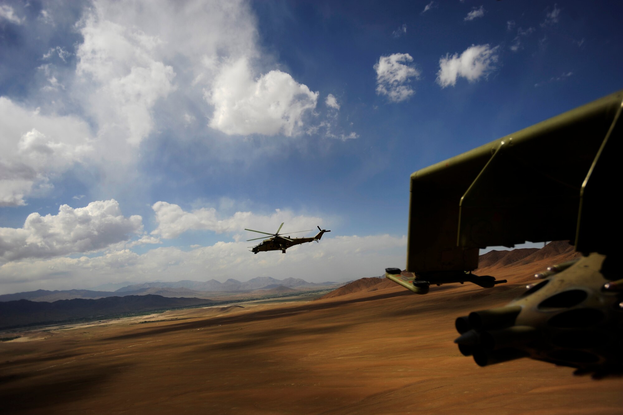 A photo taken from inside an MI-35 Hind E helicopter of another Mi-35 piloted by Hungarian Air Force Maj. Bela Lazar, Hungarian Operational Mentoring Liaison Team commander; and Afghan National Army Air Corps Capt. Gholar Mohaiudin an Mi-35 pilot, May 11, 2010, over Afghanistan. (U.S. Air Force photo/ Staff Sgt. Manuel J. Martinez/released)

