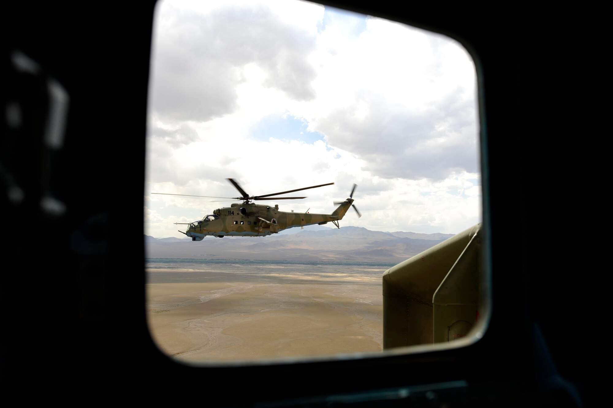A photo taken from inside an Mi-35 Hind E helicopter of a trailing Afghan National Army Air Corps Mi-35 piloted by Hungarian Air Force Maj. Bela Lazar, Hungarian Operational Mentoring Liaison Team commander, and Afghan National Army Air Corps Capt. Gholar Mohaiudin May 11, 2010, flying over Afghanistan. Some ANAAC Mi-35 pilots have more than 22 years of experience flying the airframe. (U.S. Air Force photo/ Staff Sgt. Manuel J. Martinez/released)
