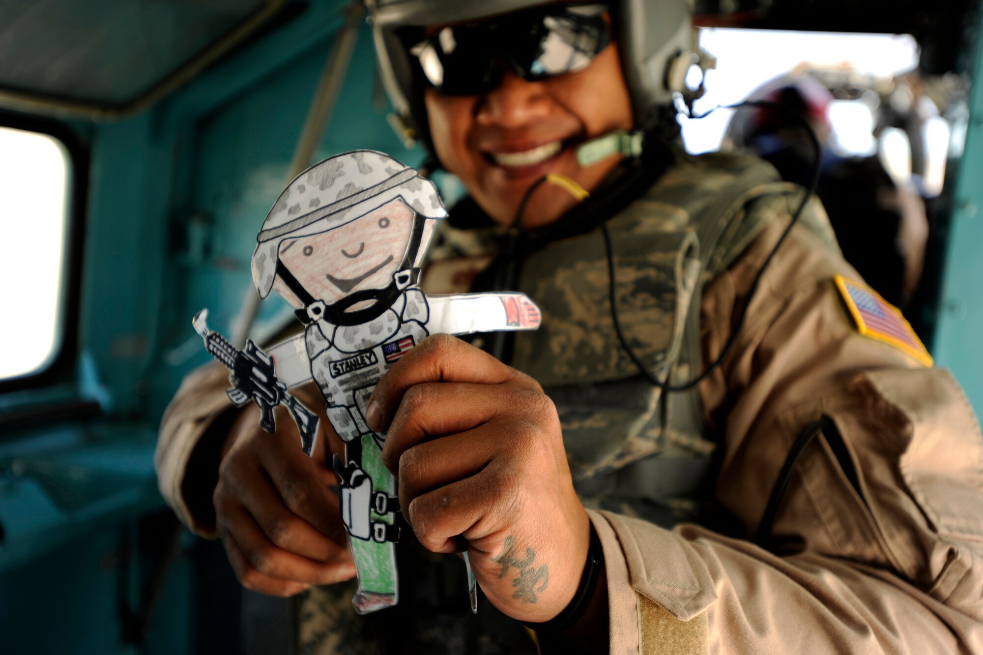 U.S. Air Force Tech. Sgt. Arthur Barad, a maintenance advisor assigned to the 440th Air Expeditionary Advisor Squadron, shows his good luck paper doll ''Flat Stanley'' given to him by his children, prior to take off aboard an Afghan National Army Air Corps Mi-35 Hind E helicopter May 11, 2010, at Kabul International Airport, Afghanistan. (U.S. Air Force photo/ Staff Sgt. Manuel J. Martinez/released)
