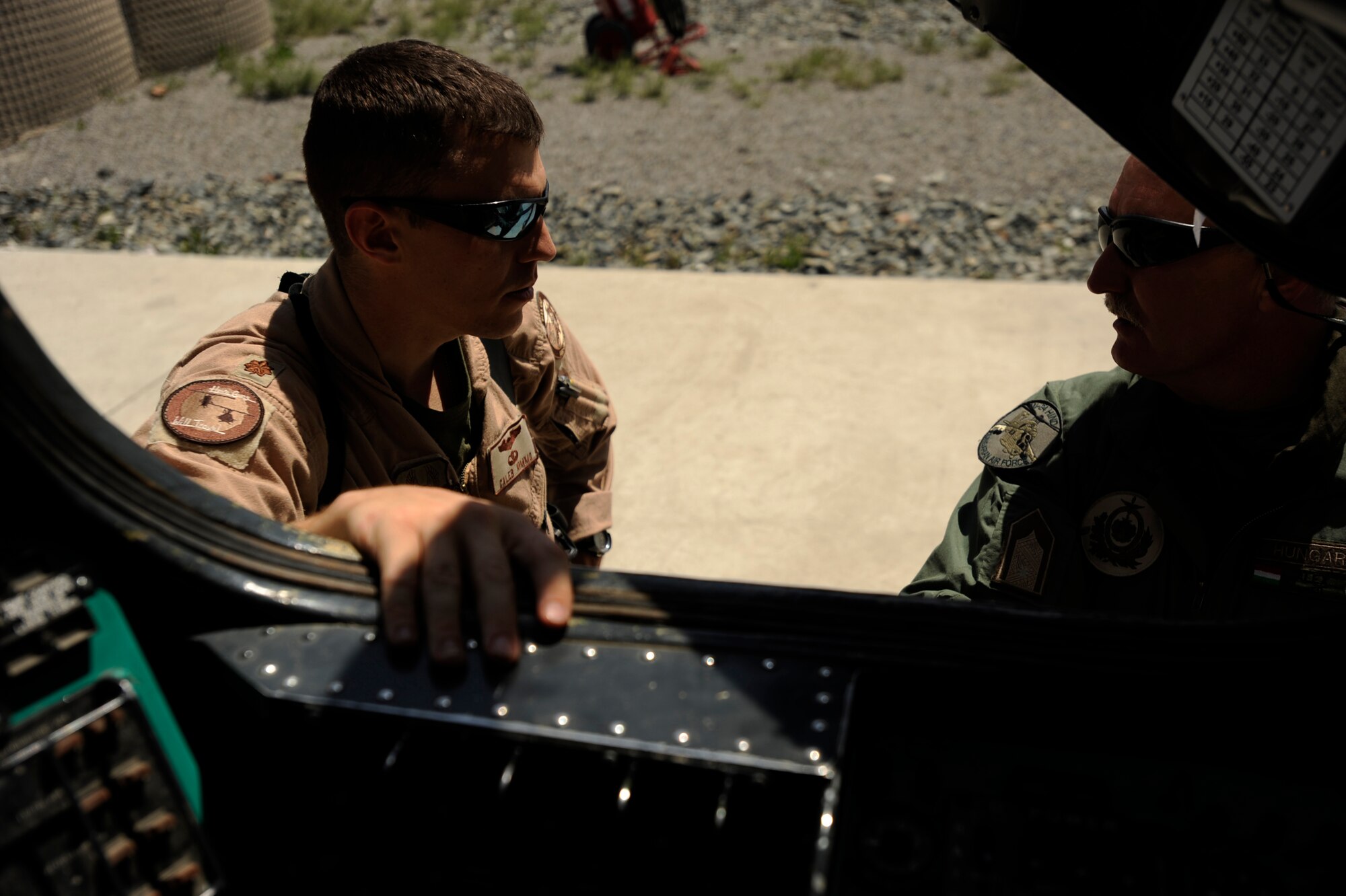 U.S. Air Force Maj. Caleb Nimmo, Mi-35 team lead assigned to the 440th Air Expeditionary Advisor Squadron, and Hungarian Air Force Maj. Szili ''Alex'' Sandor, an Mi-35 Hind E instructor pilot assigned to the Hungarian Operational Mentoring Team, discuss their live-fire training mission May 11, 2010, at Kabul International Airport, Afghanistan. (U.S. Air Force photo/ Staff Sgt. Manuel J. Martinez/released)