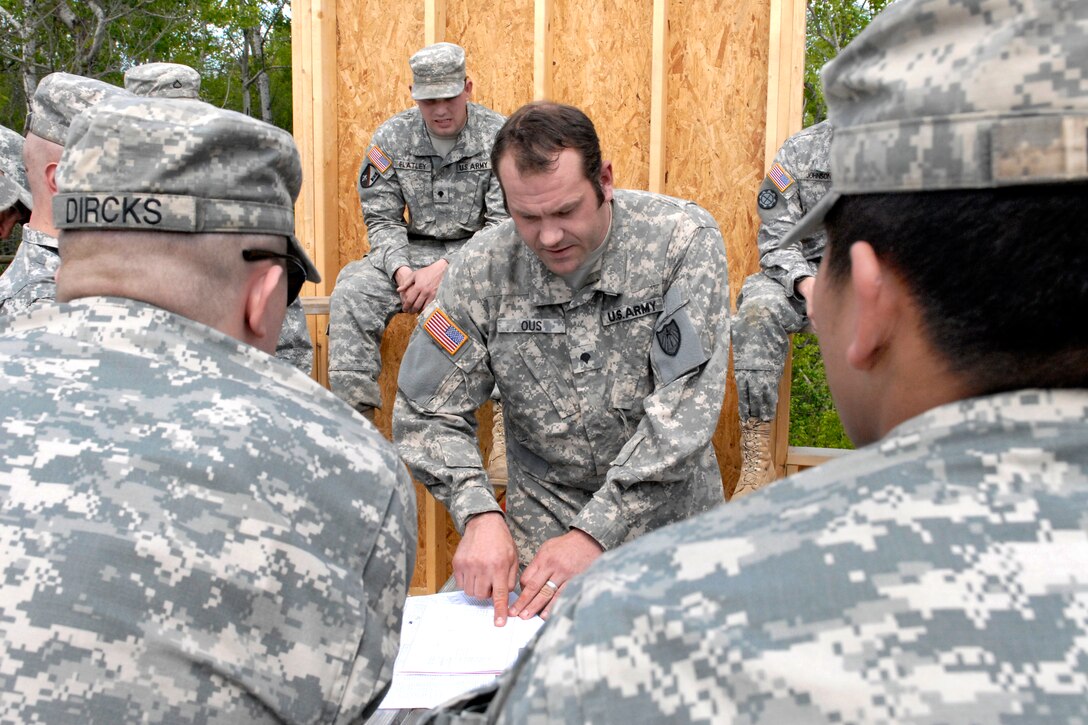 U.S. Army Spc. Jason Ous confers with other soldiers while building three cabins at the Disabled Veterans Rest Camp in Marine St. Croix, Minn., May 14, 2010. Ous is assigned to the Minnesota National Guard's 851st Vertical Engineering Company.