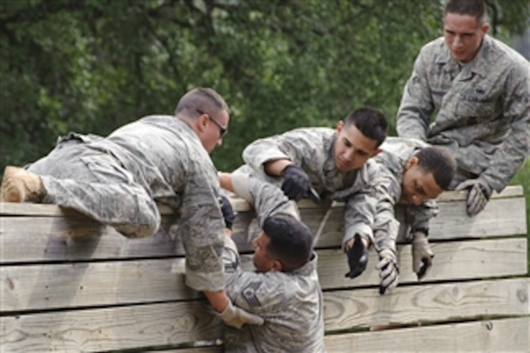 U.S. Air Force Staff Sgt. Luis Lopez of the 902nd Security Forces Squadron (2nd from left) gets assistance over a high wall from teammates Staff Sgt. Jason Roth (left), Airman 1st Class Jesse Angulo (3rd from right), Staff Sgt. Teron Mobley (2nd from right) and Airman 1st Class Jonathan Dickerson during an obstacle course and ruck march event at Camp Bullis, Joint Base San Antonio, Texas, on May 12, 2010.  The event, open to all area police organizations, was part of National Police Week, a yearly observance honoring fallen comrades.  