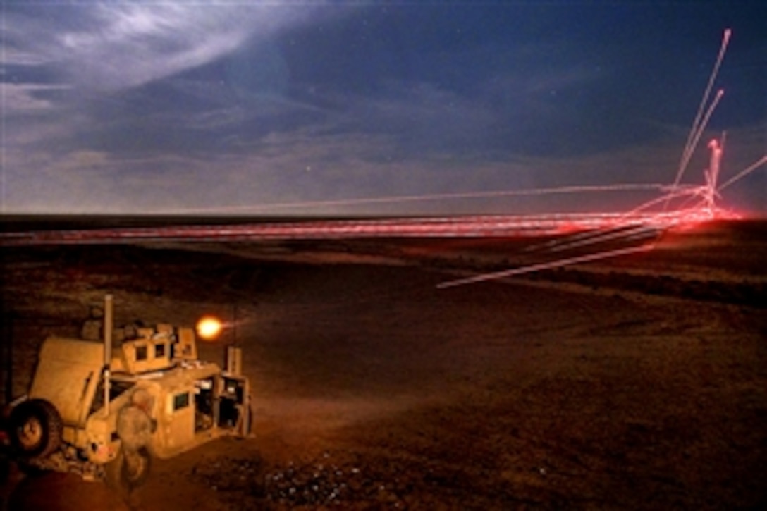 U.S. Army soldiers fire .50-caliber machine gun rounds at the base of a training target to indicate to nearby helicopters where to fire their rockets during partnered aerial-ground integration training between U.S. and Iraqi forces on Al Asad Air Base, Iraq, May 21, 2010. The soldiers are assigned to the 558th Military Police Company.