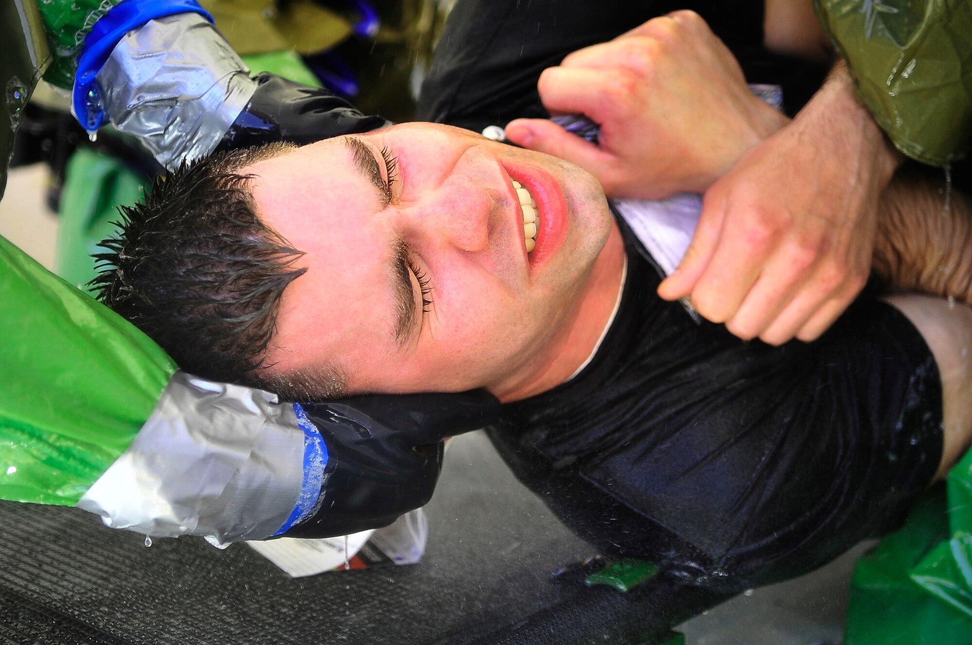 BUCKLEY AIR FORCE BASE, Colo. --  Staff Sgt. Charles Rice, 2nd Space Warning Squadron, is turned on his side as he goes through a hazardous-material (HAZMAT) decontamination line May 21. Sergeant Rice was among one hundred volunteers to act as mock casualties for an All-Hazards Response Training exercise. The multiple scenarios across the base provided training to emergency response teams in assessing and treating crisis victims of a HAZMAT incident. (U.S. Air Force photo by Staff Sgt. Kathrine McDowell)