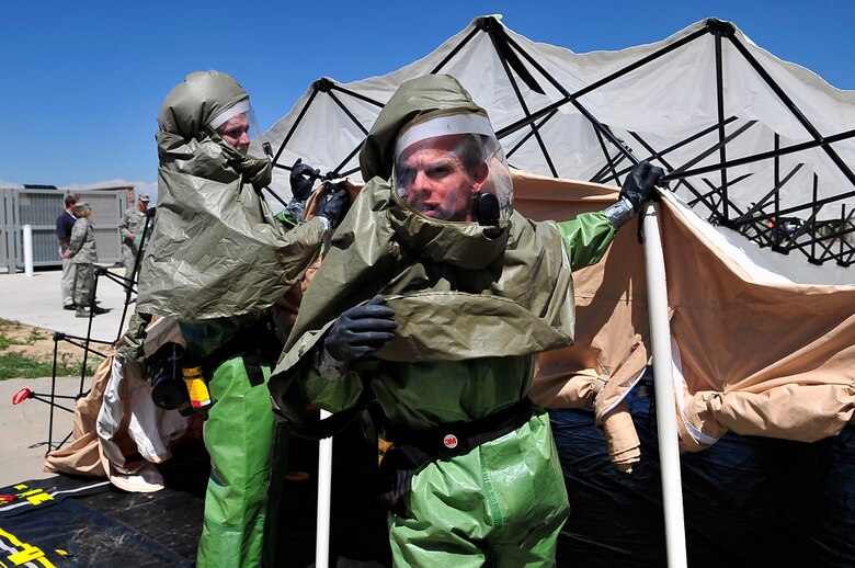 BUCKLEY AIR FORCE BASE, Colo. --  Airman Joshua Moen, 460th Medical Operations Squadron, left, and Master Sgt. Leslie Handy, 460th Medical Support Squadron, set up a hazardous-material decontamination line during an All-Hazards Training exercise May 21. 460th Medical Group emergency response teams donned Level A suits for personal protection to process and treat mock casualties of a terrorist attack scenario. (U.S. Air Force photo by Staff Sgt. Kathrine McDowell)
