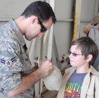 Airman 1st Class Adam Hamar, 940th Wing Public Affairs Specialist, finds himself on the other side of the camera while covering the Boy Scout Expo at Beale Air Force Base, May 1, 2010.  A young scout asked Hamar to autograph his hat as a souvenir of the event which saw 7,000 scouts participating in activities across the base. (Courtesy photo/Major John Tate).