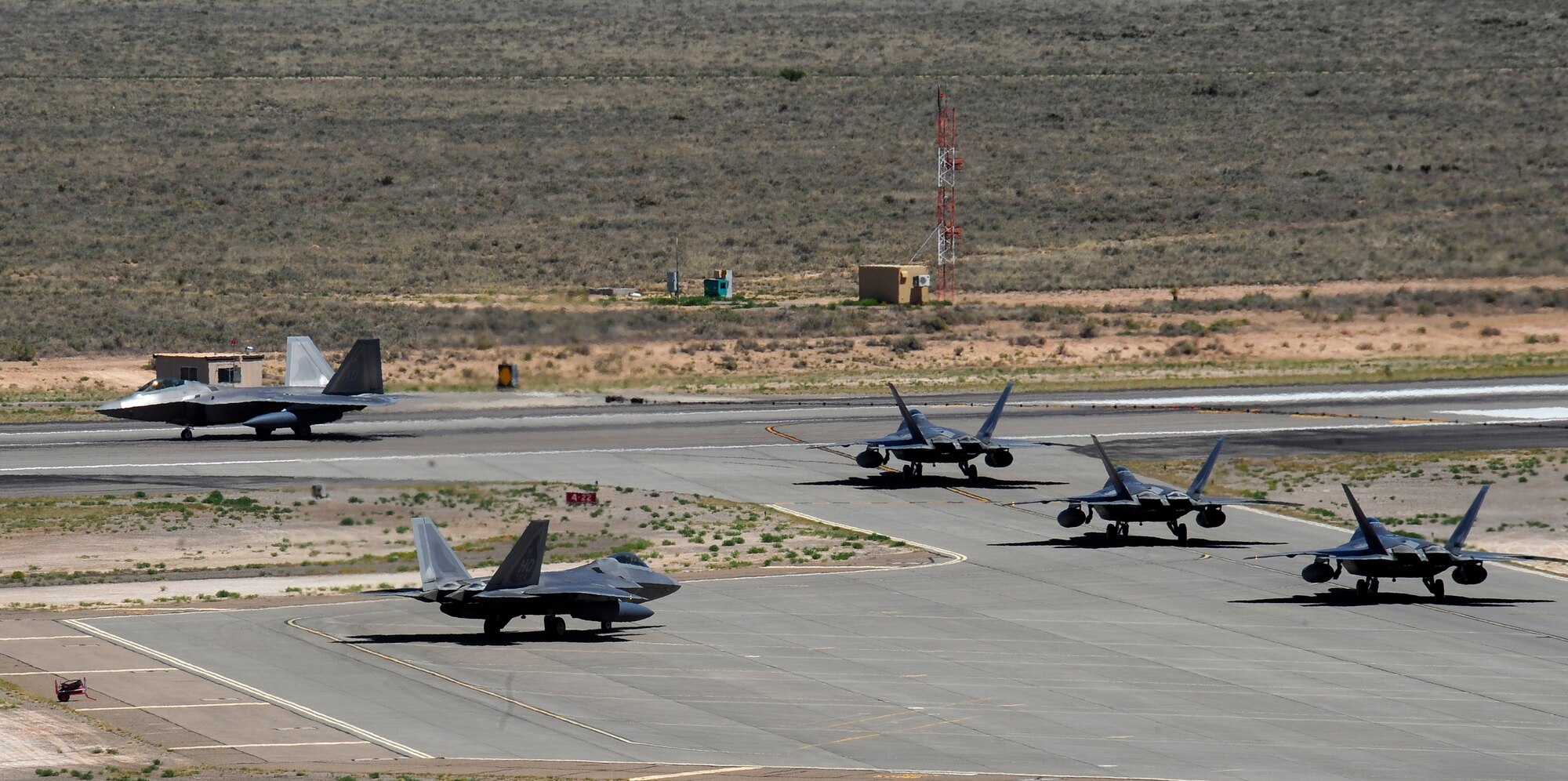 HOLLOMAN AIR FORCE BASE, N.M. -- F-22 Raptors take off from Holloman Air Force Base May 24, 2010. Members of Team Holloman and 12 Raptors deployed to Kadena Air Base, Japan, as part of continuing force posture adjustments to address worldwide requirements. The United States continues to deploy additional forces throughout the Western Pacific as part of U.S. Pacific Command’s Theater Security Package. (U.S. Air Force photo/Senior Airman Tiffany Trojca / Released)
