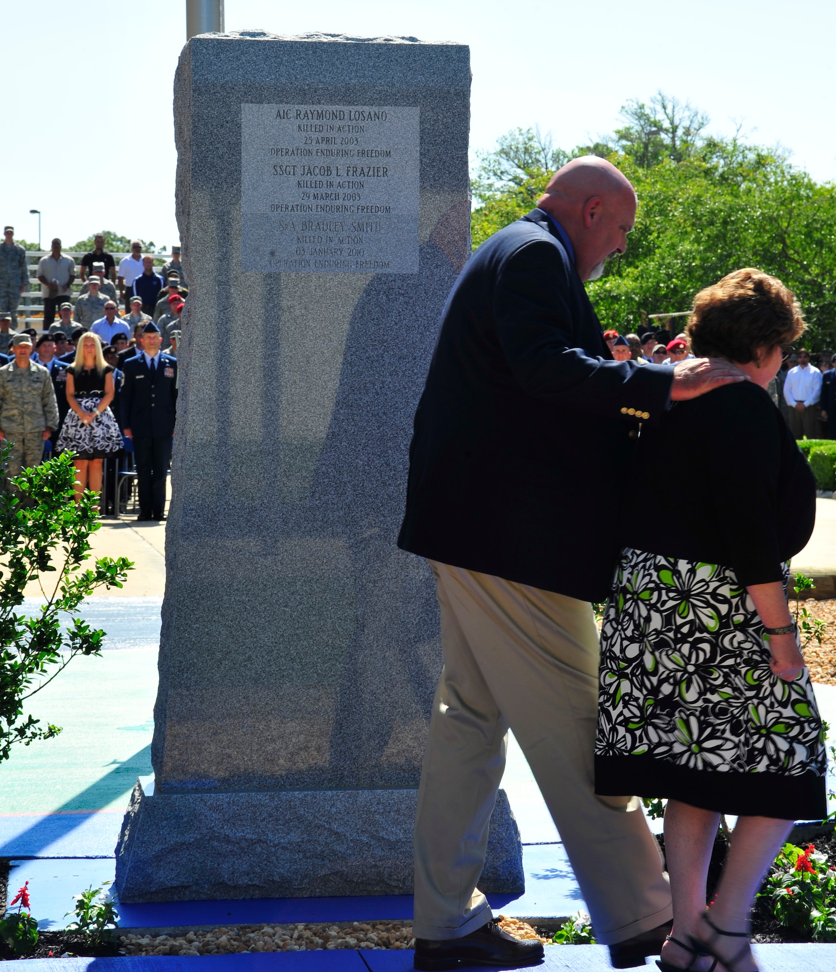 from left to right, Gary and Paula Smith, parents of Senior Airman Brad Smith, return to their seats after viewing the Tactical Air Control Party Memorial Wall after their sons name was revealed during a memorial ceremony, May 26, 2010.  While deployed in support of Operation Enduring Freedom, Airman Smith, a TACP assigned to the 10th Air Support Operations Squadron, was killed along with three other U.S. servicemembers when his unit encountered multiple improvised explosive devices Jan. 3, 2010. (DoD photo by U.S. Air Force Senior Airman Sheila Devera)