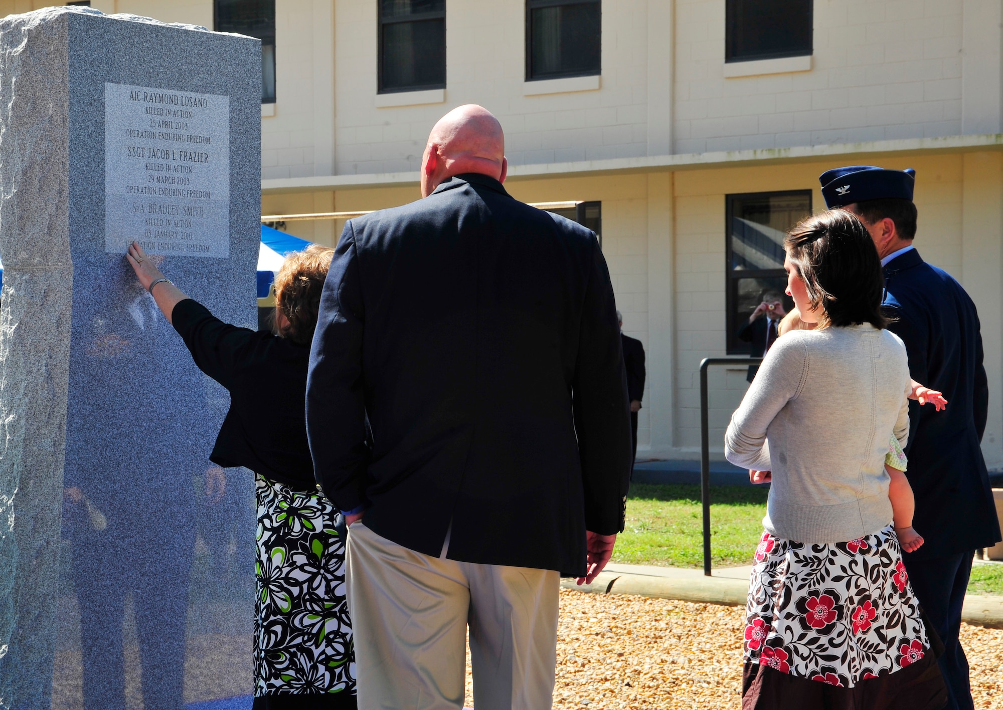 from left to right, Paula, Gary, Tiffany and Chloe Smith, parents, wife and daughter,  of Senior Airman Brad Smith, respectively, and Col. John Horner, 93rd Air Ground Operations Wing commander, view the Tactical Air Control Party Memorial Wall after Airman Smith's name was revealed during a memorial ceremony, May 26, 2010.  While deployed in support of Operation Enduring Freedom, Airman Smith, a TACP assigned to the 10th Air Support Operations Squadron, was killed along with three other U.S. servicemembers when his unit encountered multiple improvised explosive devices Jan. 3, 2010. (DoD photo by U.S. Air Force Senior Airman Sheila Devera)
