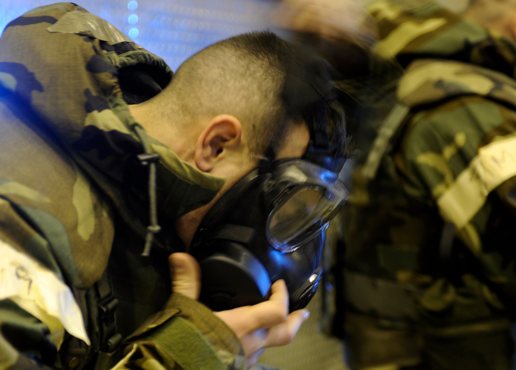 An Airman decontaminates dons his M50 field protective mask May 21, 2010, Eielson Air Force Base, Alaska. This exercise was part of the ability to survive and operate portion of the May operational readiness inspection. This Airman is assigned to the 354th Fighter Wing. (U.S. Air Force photo/Airman 1st Class Willard E. Grande II)