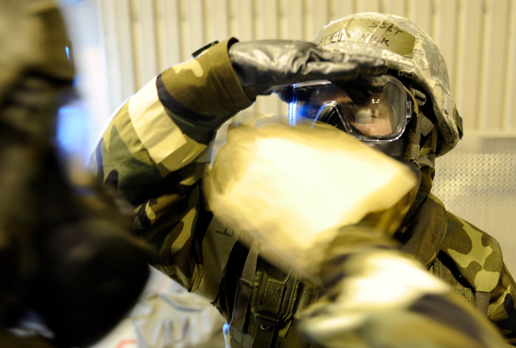 An Airman decontaminates his drinking tube while preparing to take a drink May 21, 2010, Eielson Air Force Base, Alaska. This exercise was part of the ability to survive and operate portion of the May operational readiness inspection. This Airman is assigned to the 354th Fighter Wing. (U.S. Air Force photo/Airman 1st Class Willard E. Grande II)