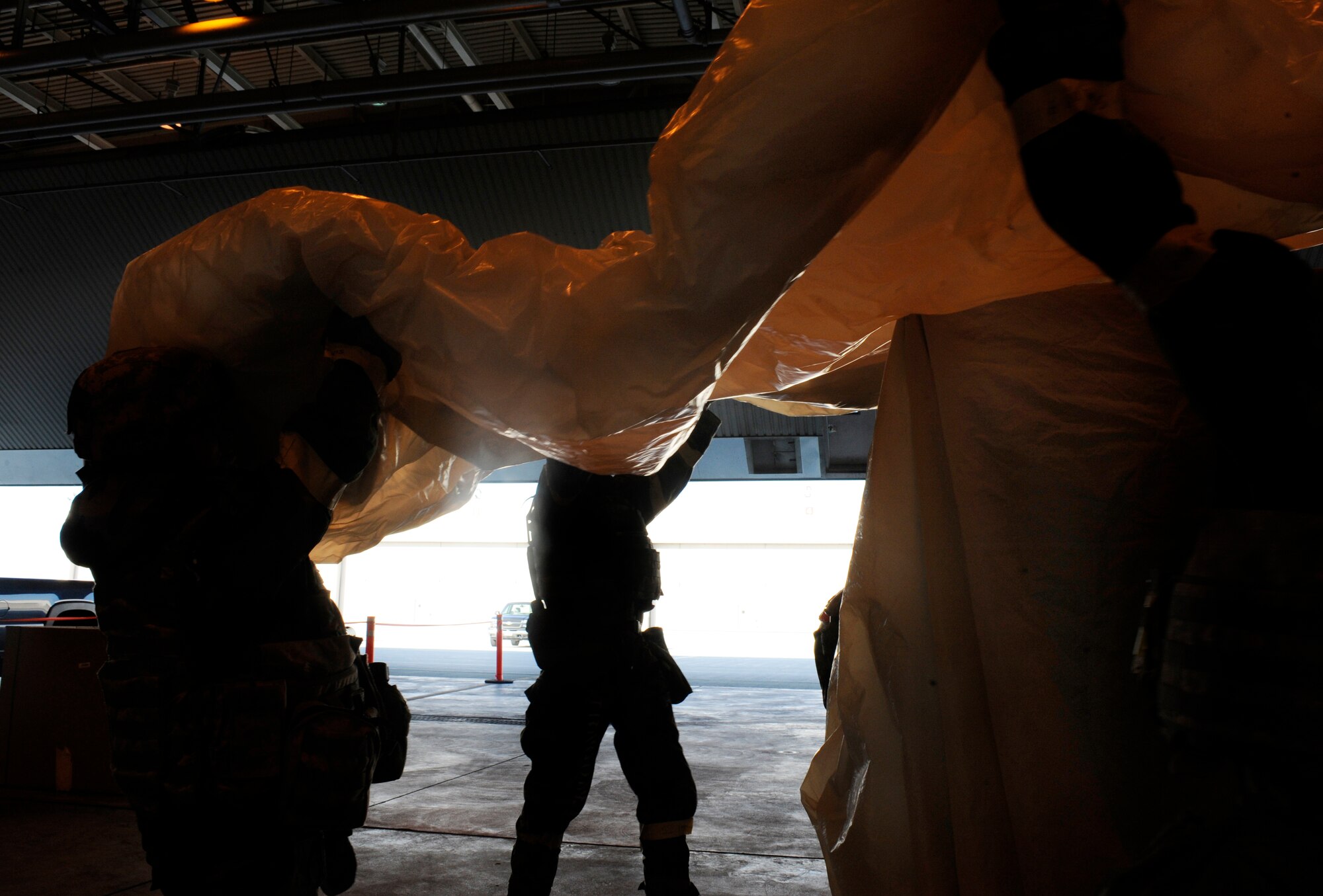Airmen cover assets to prevent them from contamination May 21, 2010, Eielson Air Force Base, Alaska. This exercise was part of the ability to survive and operate portion of the May operational readiness inspection. These Airmen are assigned to the 354th Fighter Wing. (U.S. Air Force photo/Airman 1st Class Willard E. Grande II)
