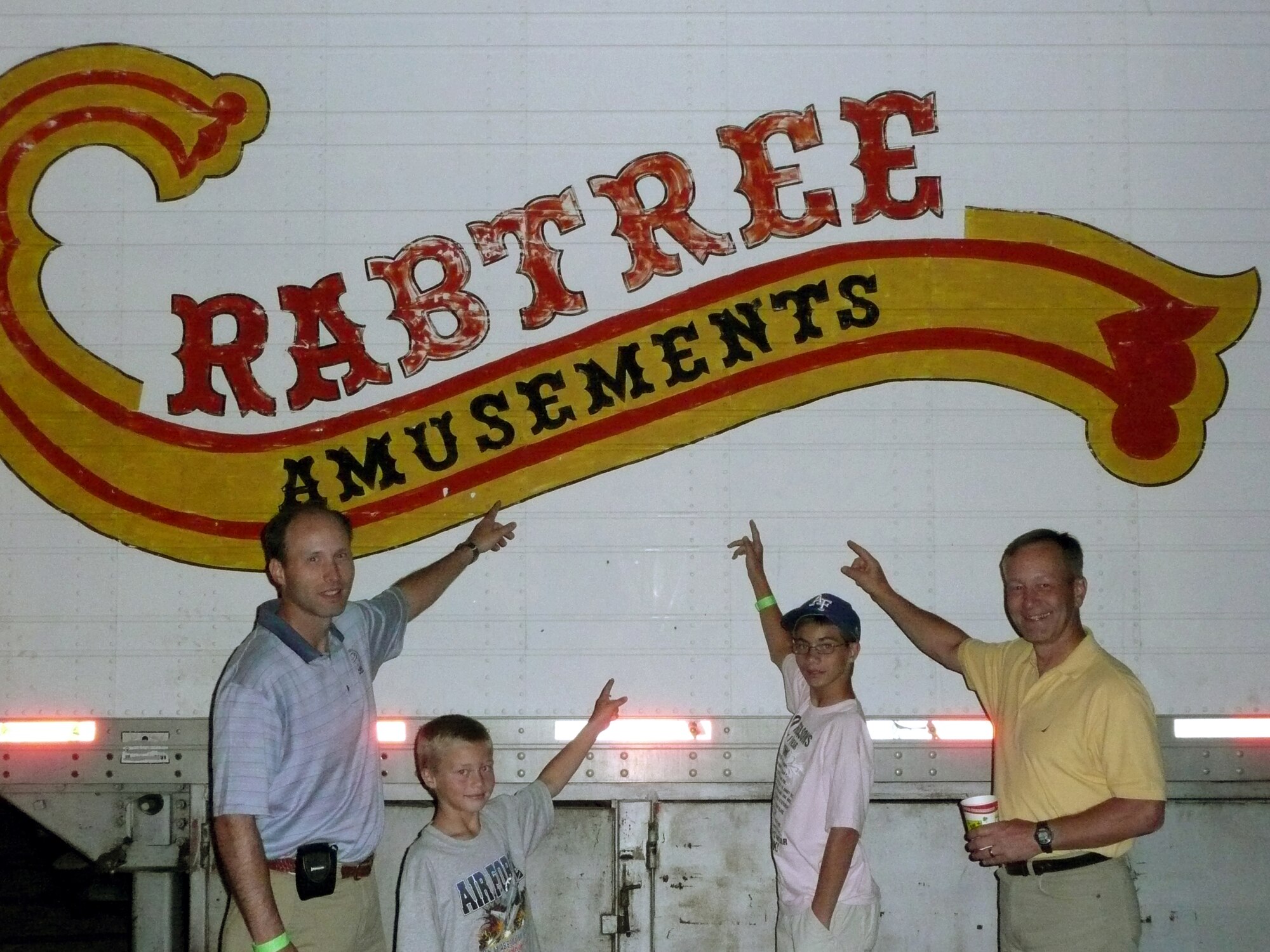 L-R:  Dana, Connor, Jordan and Eric Crabtree find an amusment company bearing their name at the Aurora County Fair, Aurora, Colo., 2008.  Dana and his sons were visiting his older brother, Eric.  Maj. Gen. Eric Crabtree is now commander, Headquarters Fourth Air Force.   (Courtesy photo)