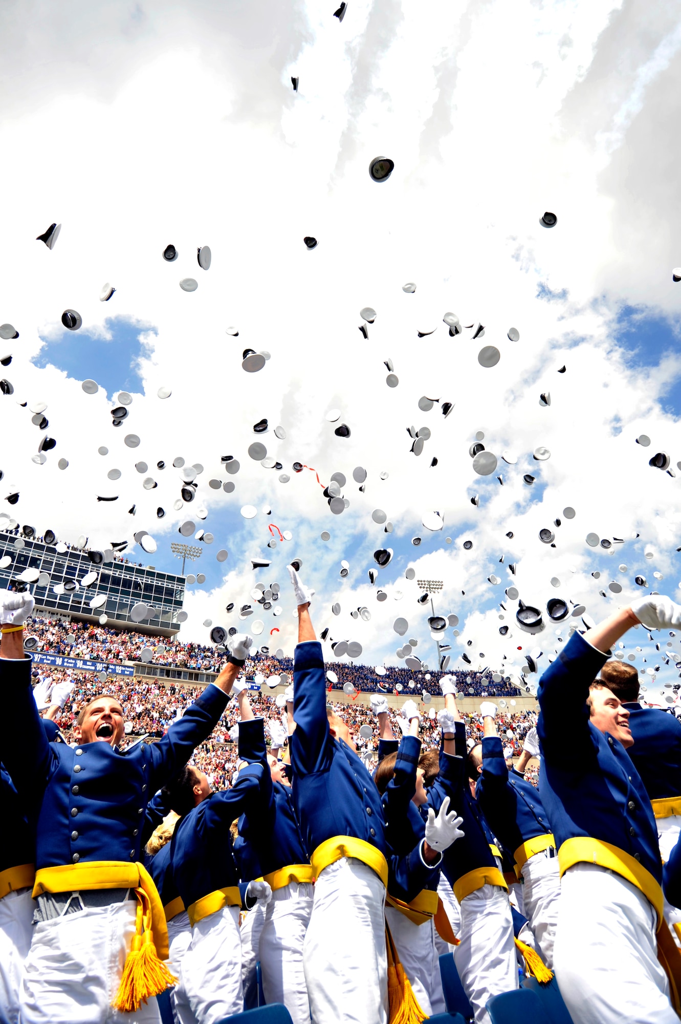 Newly commissioned second lieutenants throw their hats into the air to celebrate graduation in Falcon Stadium at the Air Force Academy May 26, 2010. The Thunderbirds U.S. Air Force Air Demonstration Team performed at the conclusion of the ceremony. (U.S. Air Force photo/Bill Evans)