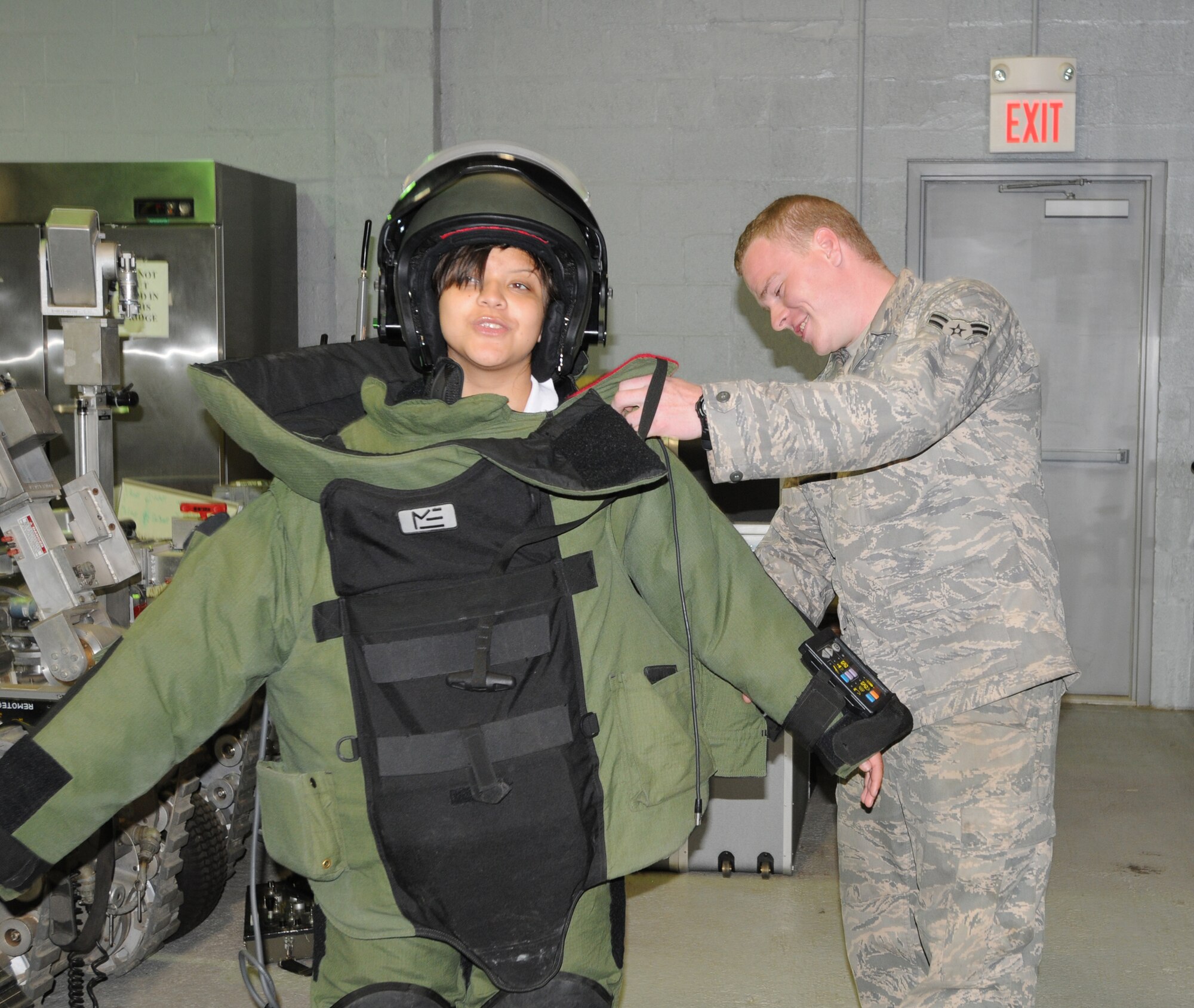 Airman 1st Class JonMichael Harry, 316th Civil Engineer Squadron, helps adjust a bomb suit on Ruth Lopez here May 26. Ms. Lopez joined 19 other students from Cardozo Senior High School, Washington, DC, on a tour of Joint Base Andrews, Md. The students also had an opportunity to speak with Airmen from the 459th Air Refueling Wing and the 316th Wing about career opportunities in both the Air Force Reserve and the regular Air Force. (U.S. Air Force photo/Staff Sgt. Steve Lewis) 