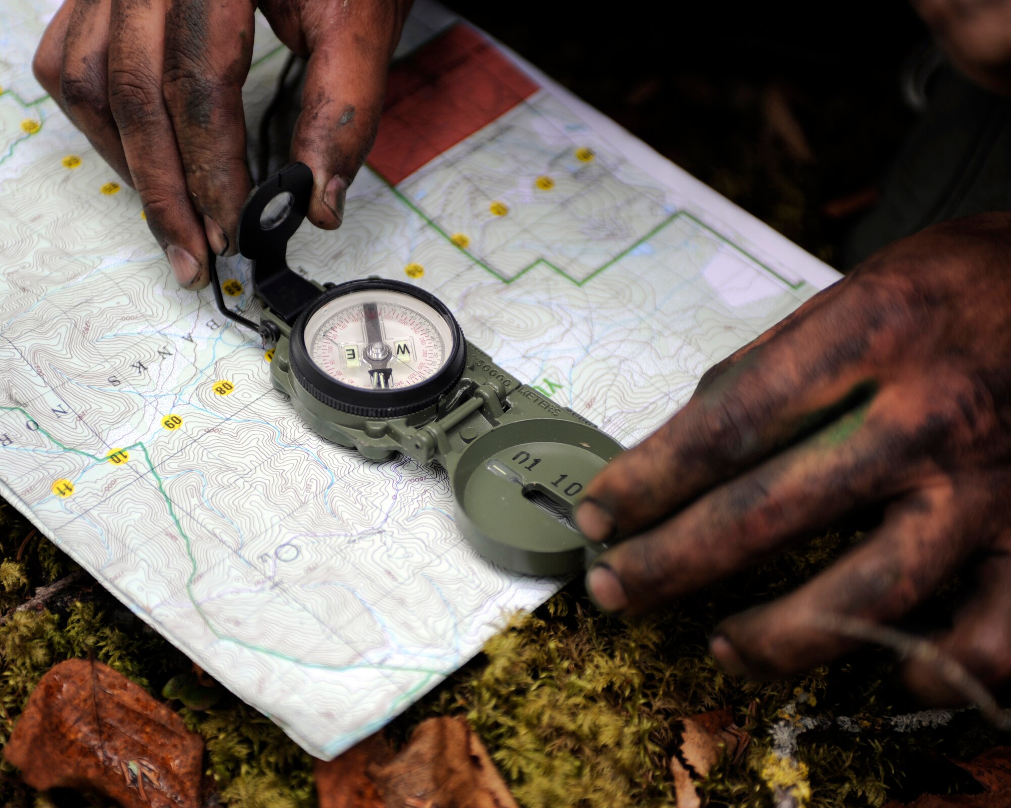 An Airman orients a map May 20, 2010, Eielson Air Force Base, Alaska. The Airman was navigation in a combat survival and evasion scenario during the May operational readiness inspection. The Airman is assigned to the 168th Air Refueling Wing. (U.S. Air Force photo/Willard E. Grande II)