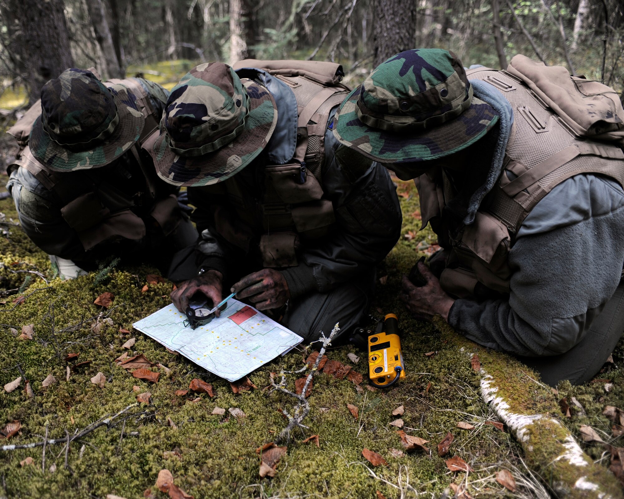 Three simulated downed pilots choose a route of travel May 20, 2010, Eielson Air Force Base, Alaska. The Airmen must navigate tactically during combat survival and evasion scenario during the May operational readiness inspection. The Airmen are assigned to the 168th Air Refueling Wing. (U.S. Air Force photo/Willard E. Grande II)