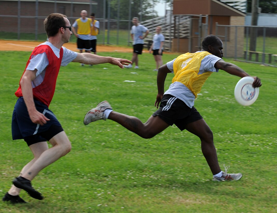 LANGLEY AIR FORCE BASE, Va. -- Staff Sgt. James Dixon, 30th Intelligence Squadron intelligence analyst, scores after catching the Frisbee while Staff Sgt. Travis Fitzgerald, 10th Intelligence Squadron network system administrator, plays defense May 26.  Ultimate Frisbee, along with other events were held as part of the 480th Intelligence, Surveillance, and Reconnaissance Wing Warrior Games.  (U.S. Air Force photo/Senior Airman Zachary Wolf) 