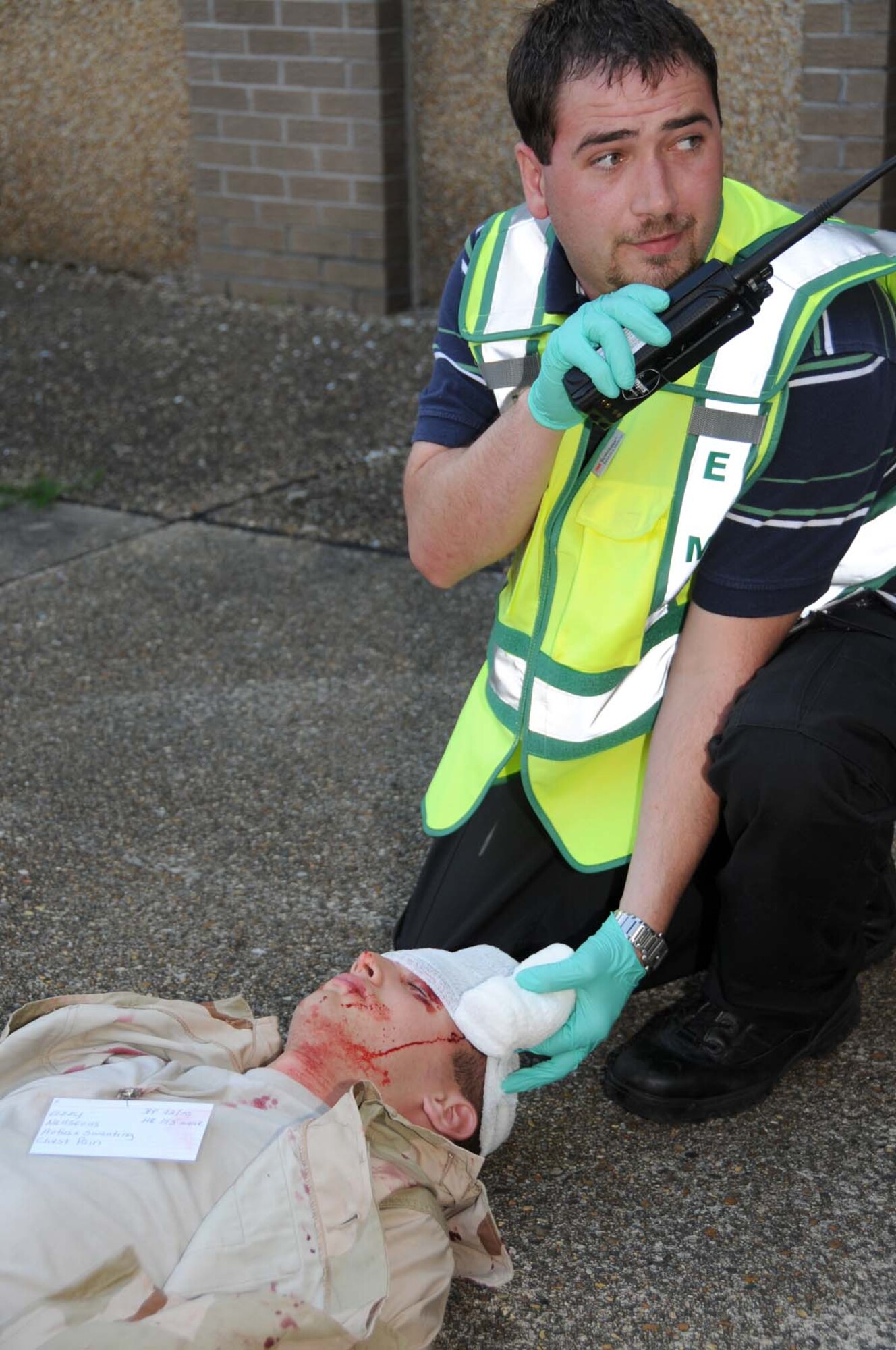 Mike Fellows, 81st Medical Operations Squadron, treats Airman Basic Andrew Hancock, 336th Training Squadron student, who portrays a victim of gunshot wounds during the exercise May 20.  (U.S. Air Force photo by Kemberly Groue)