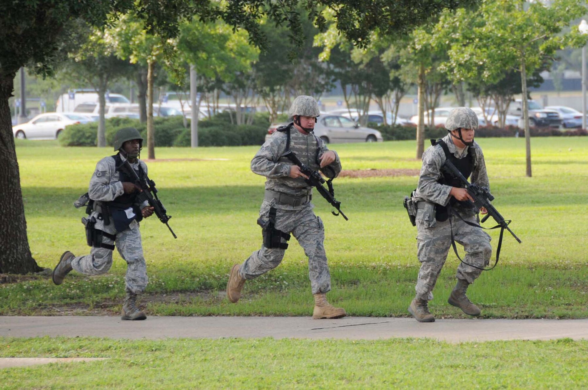 From left, Staff Sgt. Gregory Anderson, left, and Senior Airmen Kyle Dunnahoo and Robert Vogel, 81st Security Forces Squadron, charge Muse Manor in response to shots fired inside inside Muse Manor during the May 20 active shooter exercise..  In the scenario, the shooter “killed” five people and injured 15 others when he opened fire on a large group of Airmen and civilians.  (U.S. Air Force photo by Kemberly Groue)