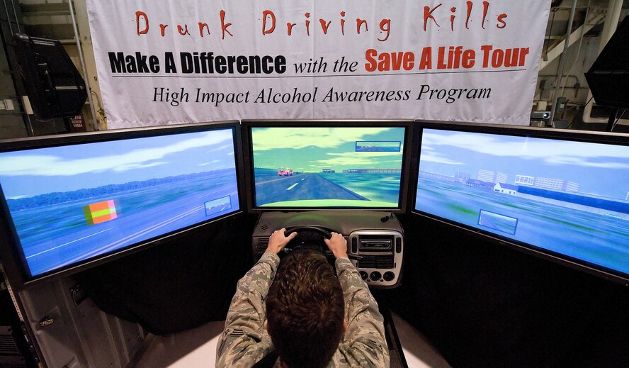 A Dover Airman uses a 2.5 million-dollar simulator during the Save a Life Tour, a National High Impact Alcohol Awareness Program. The 180-degree field of view on multi-screens helps to simulate a realistic driving experience. The computer program gradually increased the intoxication level and decreased responsiveness of the vehicle, which simulated the effect that alcohol has on the human coordination system. (U.S. Air Force photo/Jason Minto)
