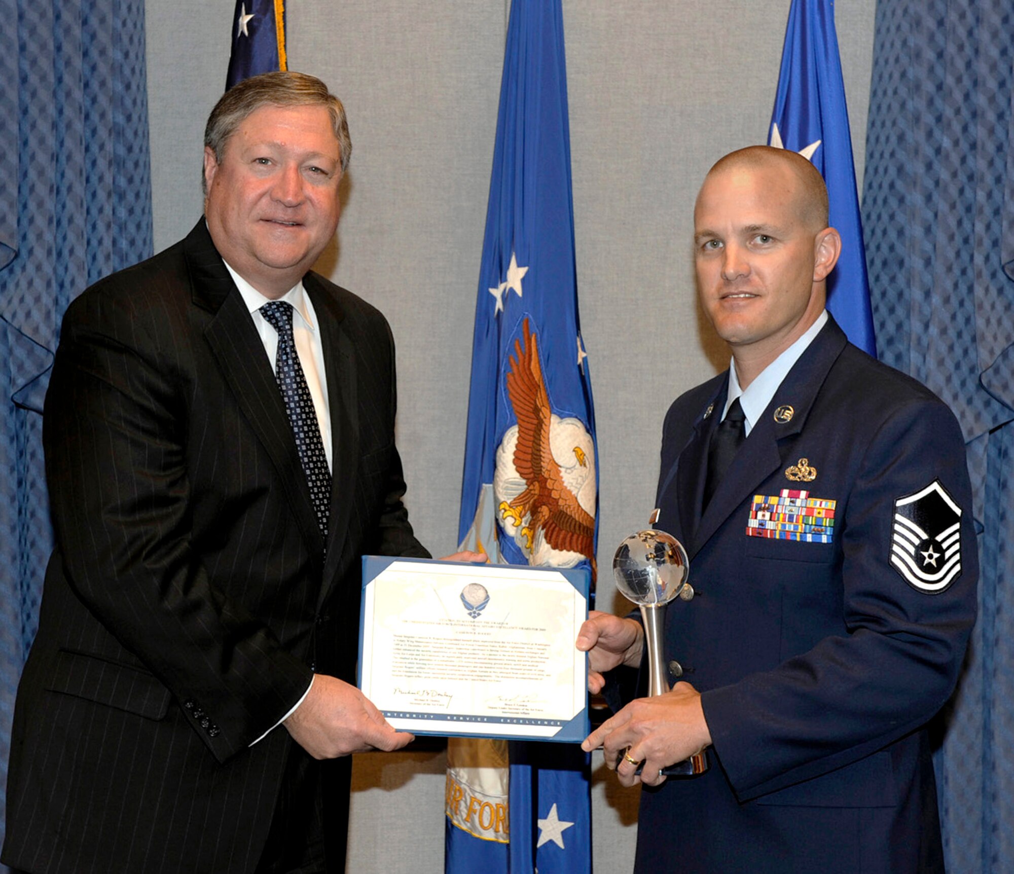 Secretary of the Air Force Michael Donley presents Master Sgt. Cameron Rogers with the Air Force International Affairs Excellence Award during a ceremony held in his honor May 24, 2010, at the Pentagon.  Sergeant Rogers, the Air Force District of Washington's command aircraft maintenance manager, received this award for his service on a year-long deployment with the Combined Airpower Transition Force in Kabul, Afghanistan. (U.S. Air Force photo/Andy Morataya)