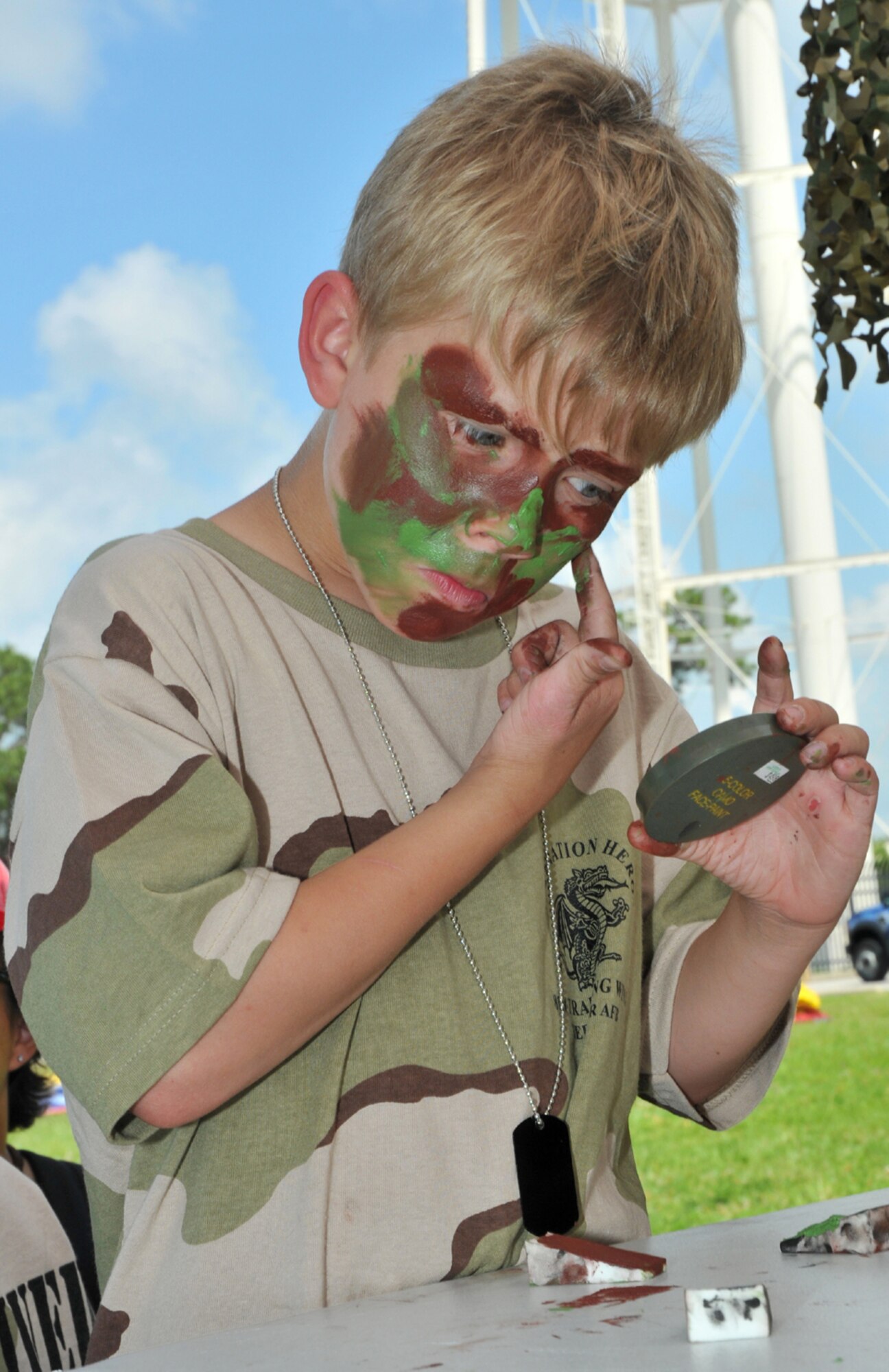 Logan Carlson, 8, applies face paint.  Logan, 8, is the son of Maj. Matthew and Sherry Carlson, 403rd Wing.  (U.S. Air Force photo by Adam Bond)