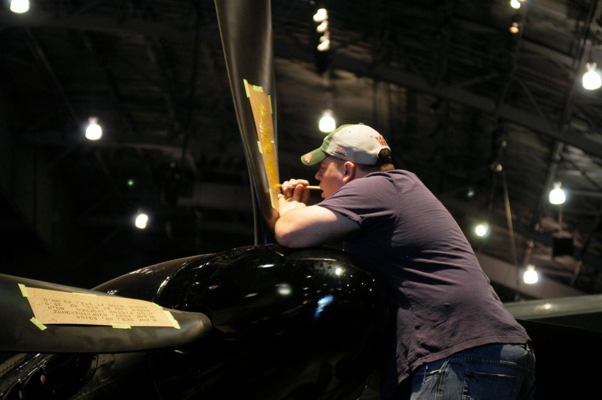 DAYTON, Ohio (05/2010) -- In preparation for the 60th anniversary of the Korean War, the National Museum of the U.S. Air Force is renovating its Korean War exhibit. Here, a restoration specialist paints stenciling on the F-82. (U.S. Air Force photo)