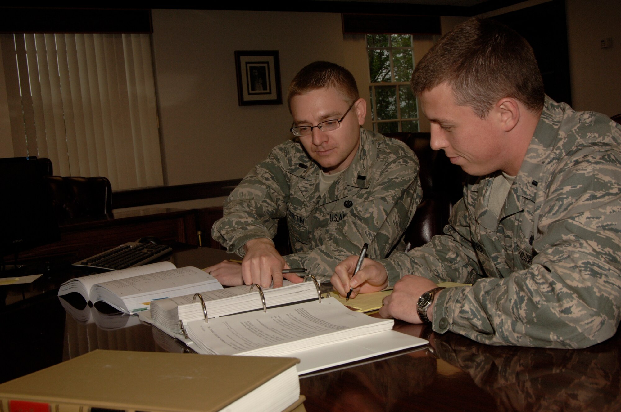 SCOTT AIR FORCE BASE, Ill. -- Staff Judge Advocate attorneys 1st Lieutenants Seth Dilworth and Pete Havern take notes and consult Air Force regulations. (U.S. Air Force photo by Airman 1st Class Amber Kelly-Herard)