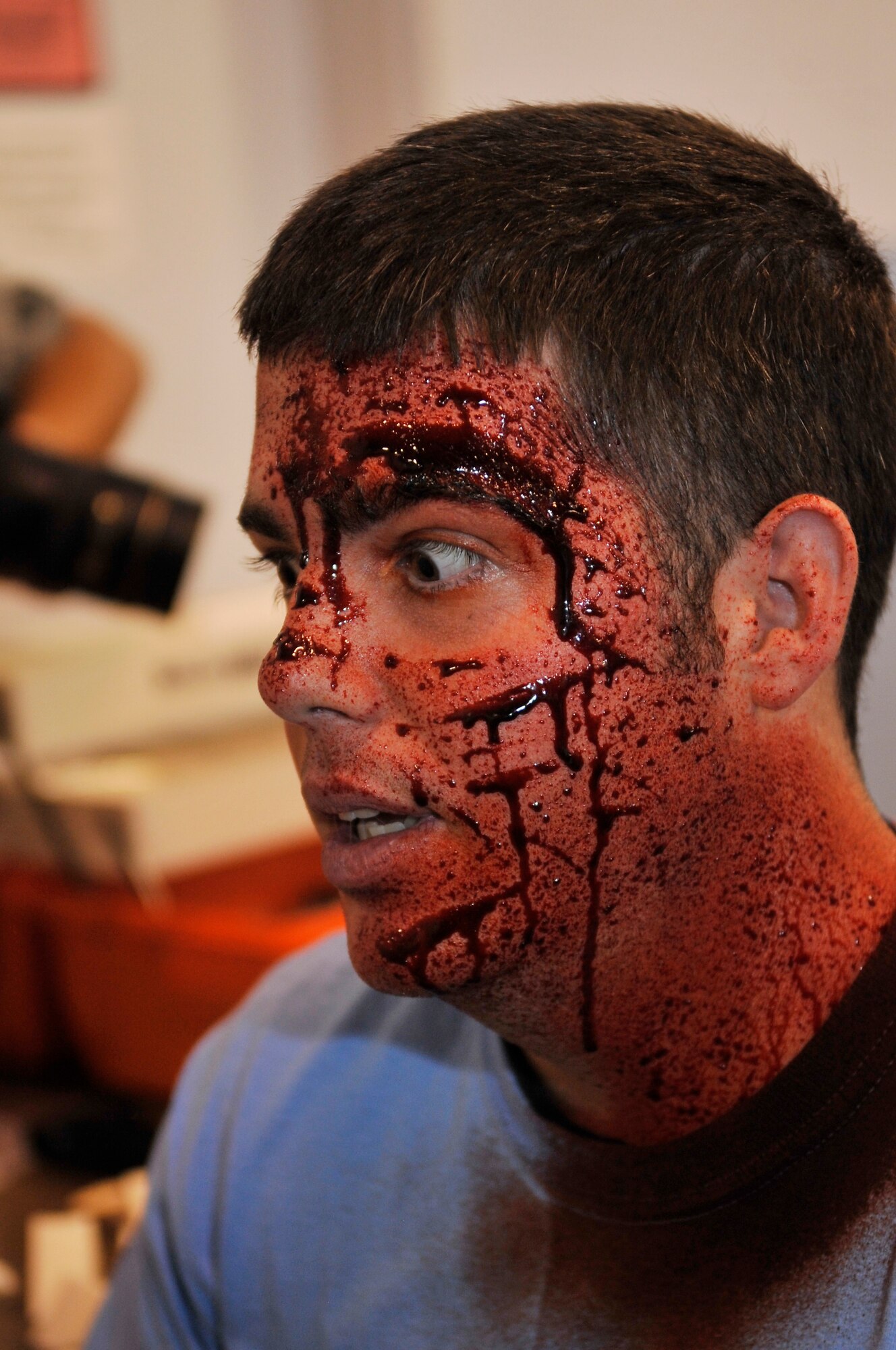 BUCKLEY AIR FORCE BASE, Colo. -- Airman 1st Class Benjamin Young, 460th Comptroller Squadron, reacts after moulage was applied to his face May 21. Emergency responders treated several simulated injuries during the All-Hazards Response Exercise with the City of Aurora. (U.S. Air Force photo by Airman 1st Class Paul Labbe)