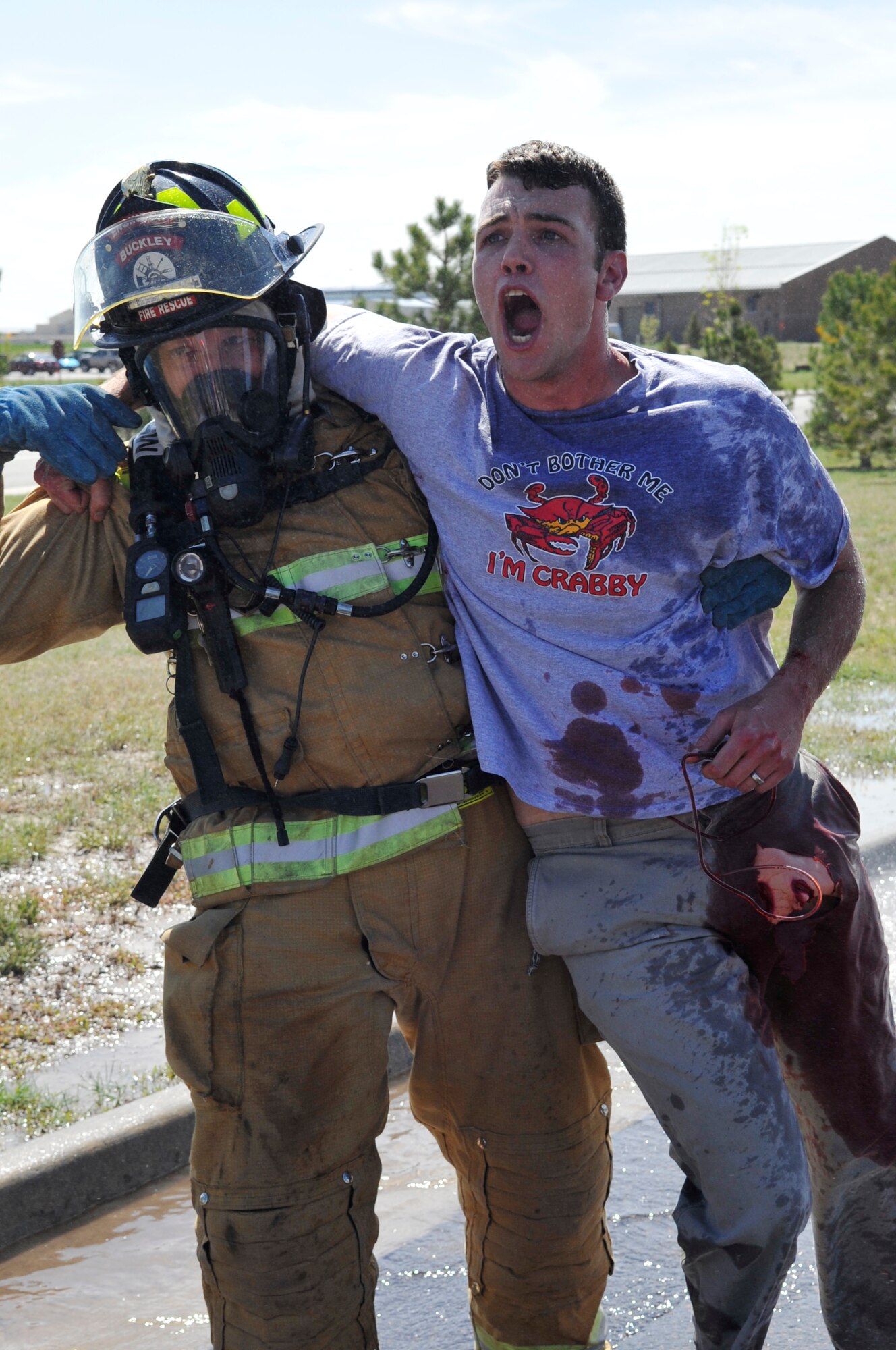 BUCKLEY AIR FORCE BASE, Colo. -- A Buckley firefighter carries Senior Airman Kris Martin, 460th Civil Engineer Squadron, during the All-Hazards Response Training exercise May 21. Airman Martin played the role of a casualty during the exercise.(U.S. Air Force photo by Airman 1st Class Paul Labbe)