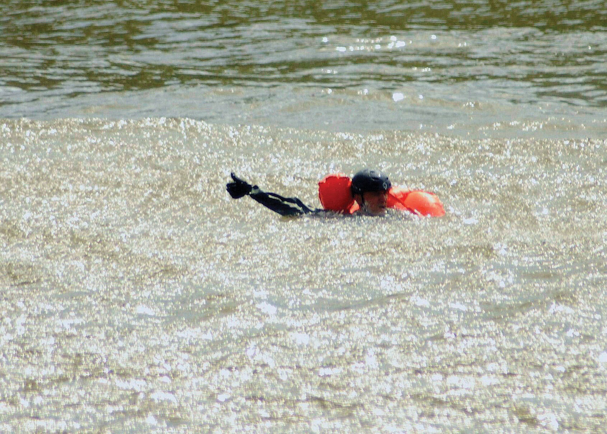 While dealing with the strong current and the rotor wash, a water-survival trainee signals his readiness before beig hoisted out of the Alabama River by an Alabama Department of Public Safety helicopter.  (Air Force photo by Gene H. Hughes)