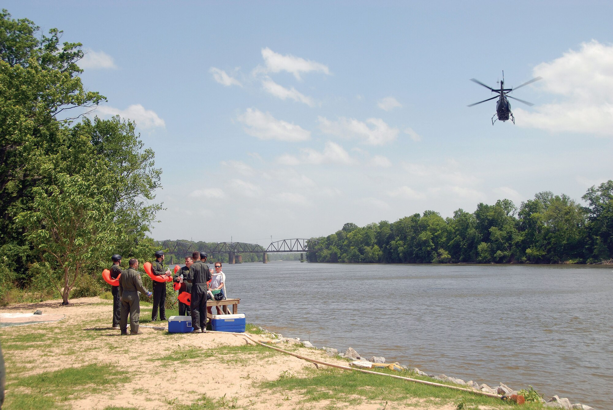 Member of the 908th Airlift Wing gather at the banks of the Alabama River in Millbrook, Ala. in preparation for mandatory water-survival training. A helicopter from the Alabama Department of Public Safety, which also took part in the training, flies overhead.  (Air Force photo by Gene H. Hughes)