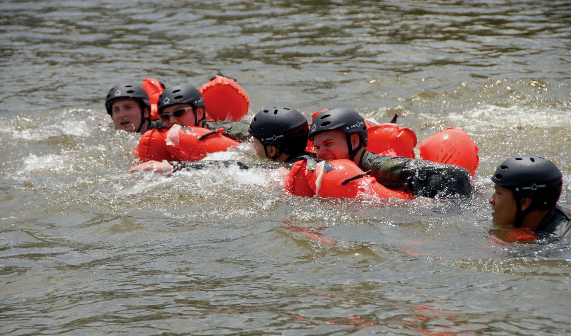 Trainees fight against the current to reach a raft during water-survival training. Getting wet wasn’t the only challange. A 35-knot wind and a four-knot current played havok with the day's training. Swimmers were carried about 150 yards within a matter of moments and separate rescue rafts were torn loose from 50-pound cinder blocks.  (Air Force photo by Gene H. Hughes)