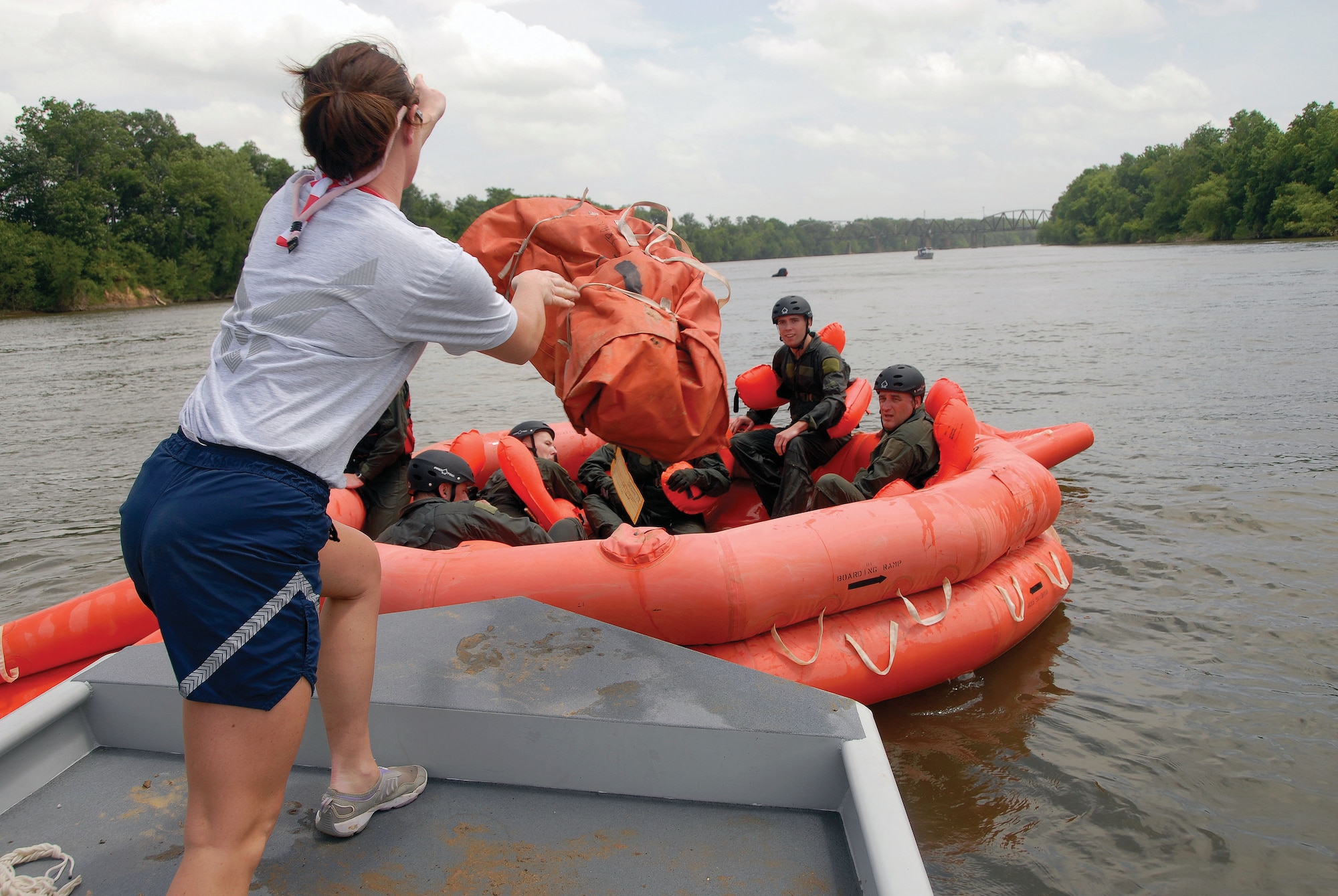 Staff Sgt. Ashley Hill of the 908th Operation Support Flight assists ‘survivors’ during the wing's mandated water-survival training at the Alabama River in Millbrook, Ala.  (Air Force photo by Gene H. Hughes)