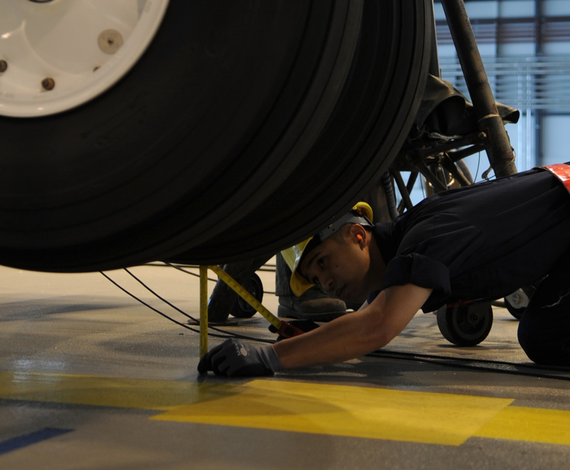U.S. Air Force Airman 1st Class Joel Rivera 86th Maintenance Squadron isochronal crew chief, measures the height of the C-130J off the ground during an isochronal inspection, Ramstein Air Base, Germany, May 26, 2010. This is the first C-130J all active duty isochronal inspection done in the Air Force. (U.S. Air Force Photo by Airman 1st Class Caleb Pierce)