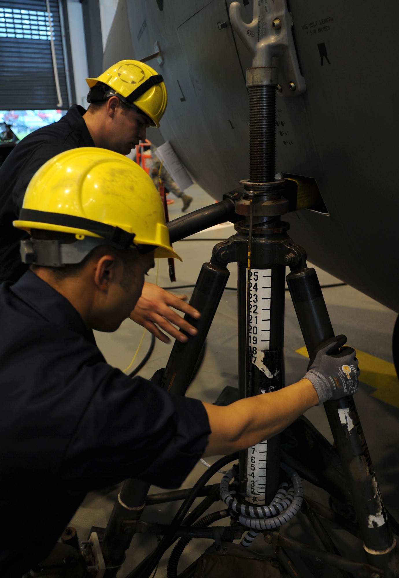 U.S. Air Force Airman 1st Class Joel Rivera and Senior Airman Joshua Sauer, 86th Maintenance Squadron isochronal crew chiefs, put a jack in place for a full aircraft jacking during an isochronal inspection, Ramstein Air Base, Germany, May 26, 2010. This is the first C-130J all active duty isochronal inspection done in the Air Force. (U.S. Air Force Photo by Airman 1st Class Caleb Pierce)   