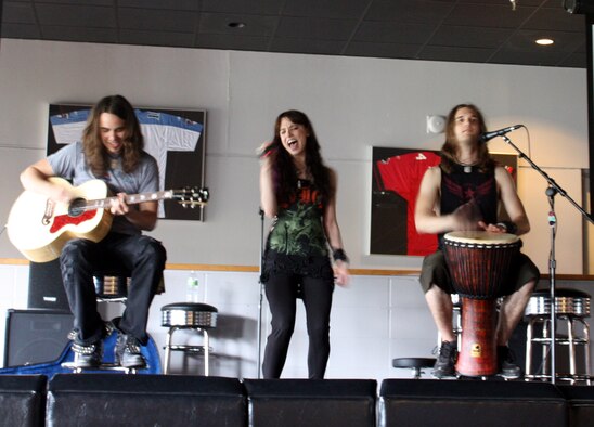 Halestorm guitarist Joe Hottinger, left, singer Lzzy Hale, center, and drummer Arejay Hale, right, perform a song from their album during a special acoustic performance at the Landing Zone at Hurlburt Field, Fla., May 25, 2010. The concert was the first ever held at the venue, as well as the band’s first appearance on a military installation. (DoD photo by Dianne Bitzes)