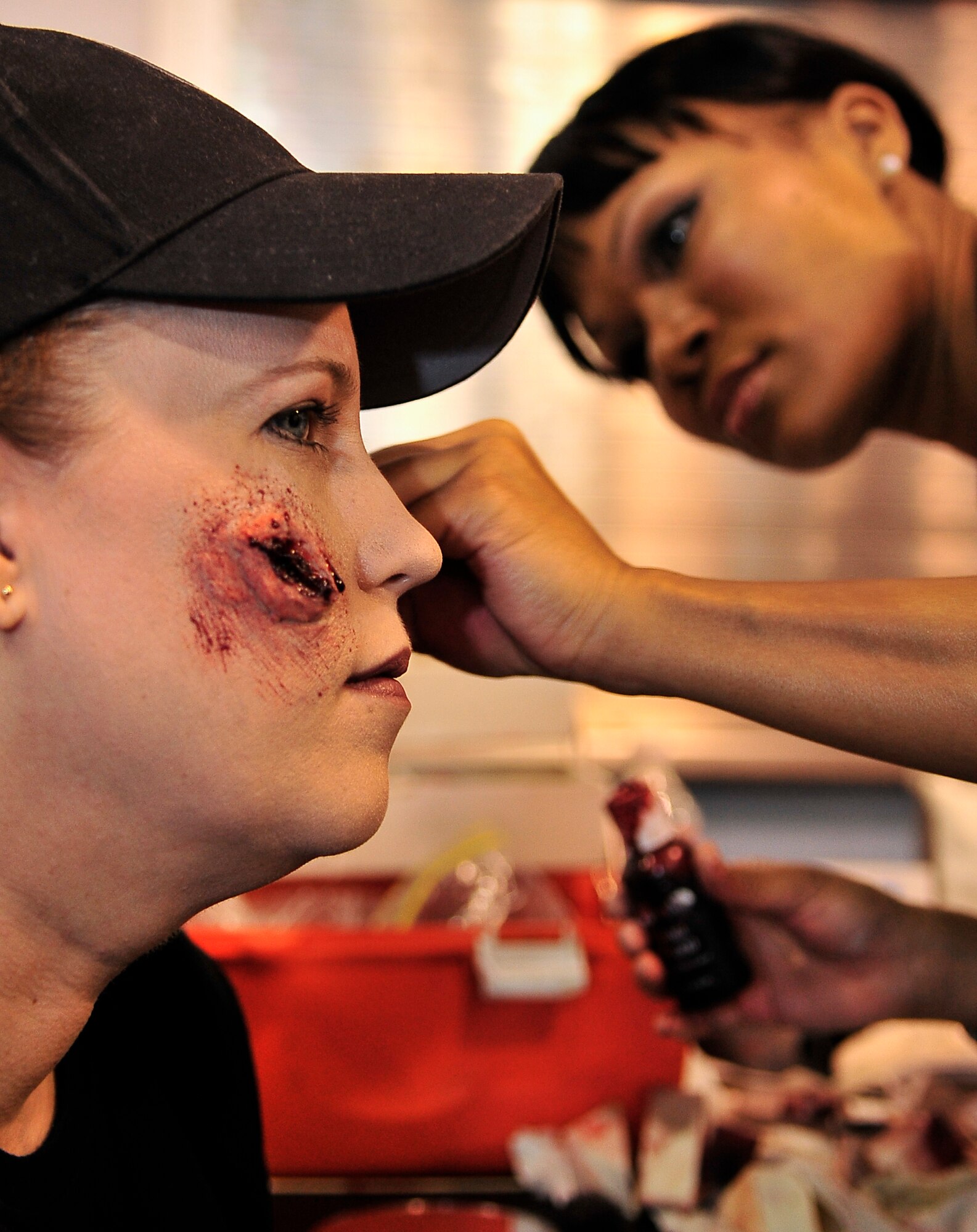 BUCKLEY AIR FORCE BASE, Colo. -- Technical Sgt. Teresa Forward, 460th Medical Operations Squadron, applies moulage to Staff Sgt. Melody Tucker, 460th Space Communications Squadron, before an All-Hazards Response Training exercise May 21. These mock injuries provide emergency responders more realistic training in assessing the care of crisis victims. (U.S. Air Force photo by Staff Sgt. Kathrine McDowell)