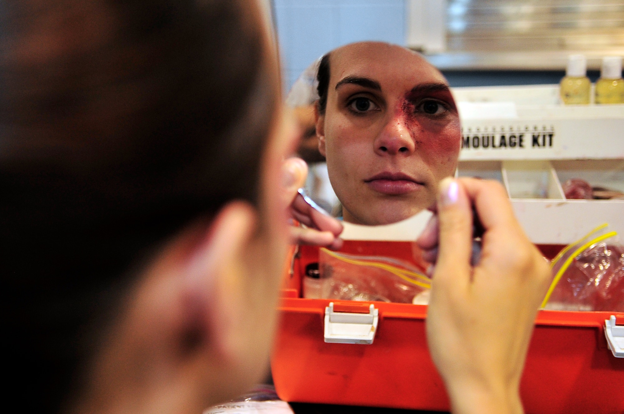 BUCKLEY AIR FORCE BASE, Colo. --  Staff Sgt. Ashley Tiffin, 460th Space Wing Judge Advocate office, takes a glance at her mock eye injury before an All-Hazards Response Training exercise May 21. These mock injuries provide emergency responders with more realistic training in assessing the care of crisis victims. (U.S. Air Force photo by Staff Sgt. Kathrine McDowell)