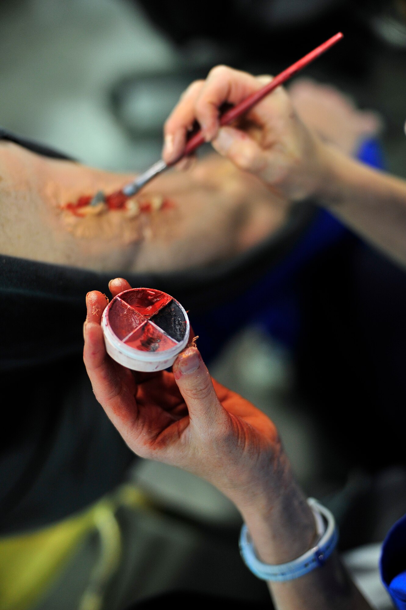 BUCKLEY AIR FORCE BASE, Colo. -- Master Sgt. Jan Shain, 460th Medical Support Squadron, works on a mock injury using her moulage kit May 21. Sergeant Shain has been applying moulage during emergency response training scenarios since she first enlisted in the Air Force. (U.S. Air Force photo by Staff Sgt. Kathrine McDowell)