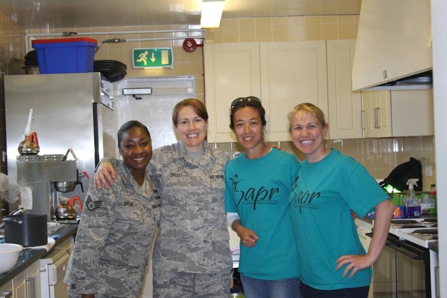 RAF CROUGHTON, United Kingdom - (Left to right) Victim Advocates Staff Sgt. Kendra Bryan, Tech. Sgt Leigh-Ann Stout, 501st Combat Support Wing Sexual Assault Coordinator, Mrs. Kimberly Dickman and Tech. Sgt. Anna Keck take a break from cooking for the Women's Luncheon held at here April 28 as part of a series of events promoting Sexual Assault Awareness Month throughout April. (courtesy photo)