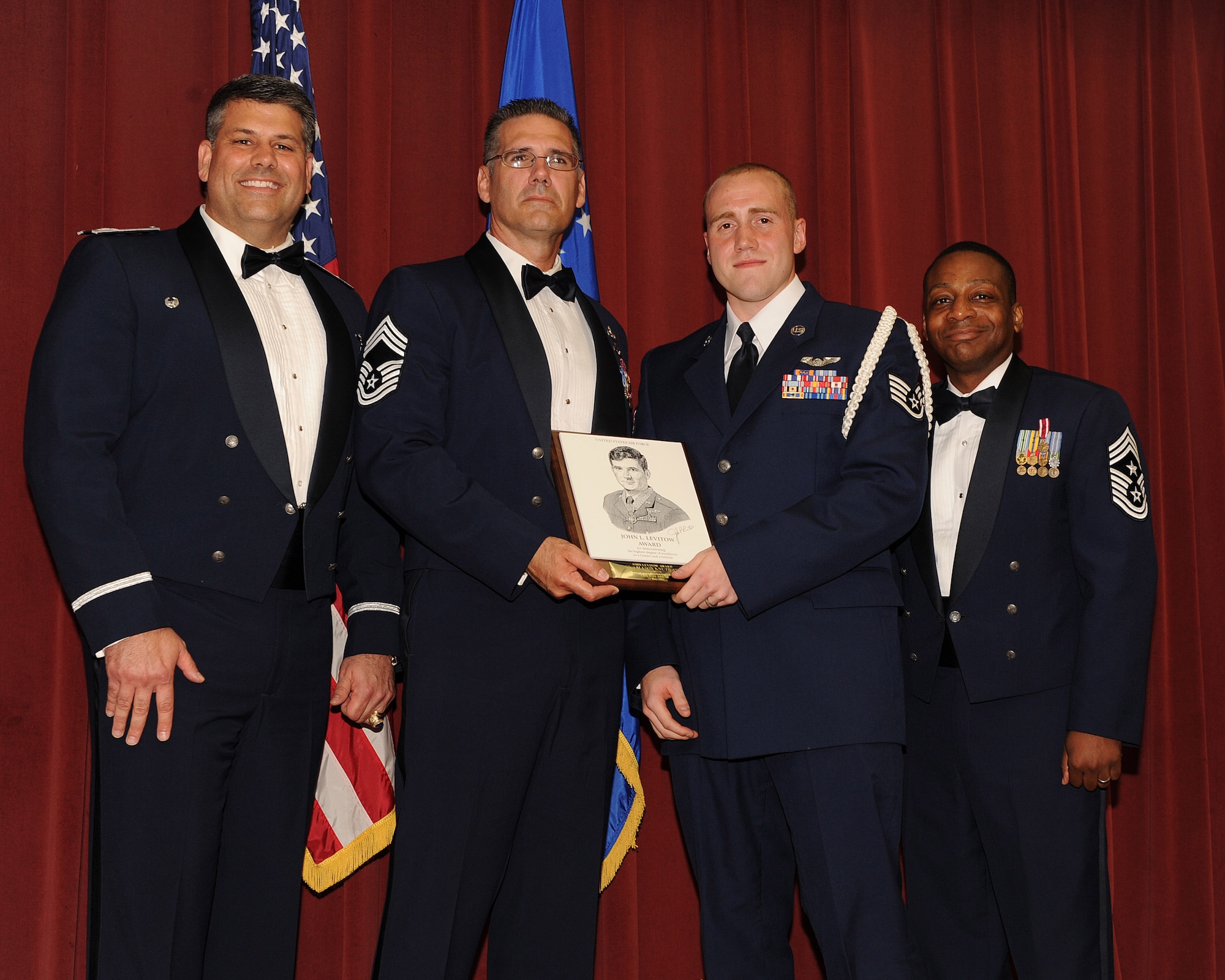 (Third from left) Staff Sgt. Mason Knuthson, 41st Airlift Squadron loadmaster, is presented the John L. Levitow Award May 25 by Col. Greg Otey, 19th Airlift Wing commander; Chief Master Sgt. Craig Best, 19th Operations Group superintendent; and Chief Master Sgt. Anthony Brinkley, 19th AW command chief; at the Thomas Community Activities Center. The Levitow Award is presented to the top performing Airman in each class at Airman Leadership School. (U.S. Air Force photo by Staff Sgt. Chad Chisholm)