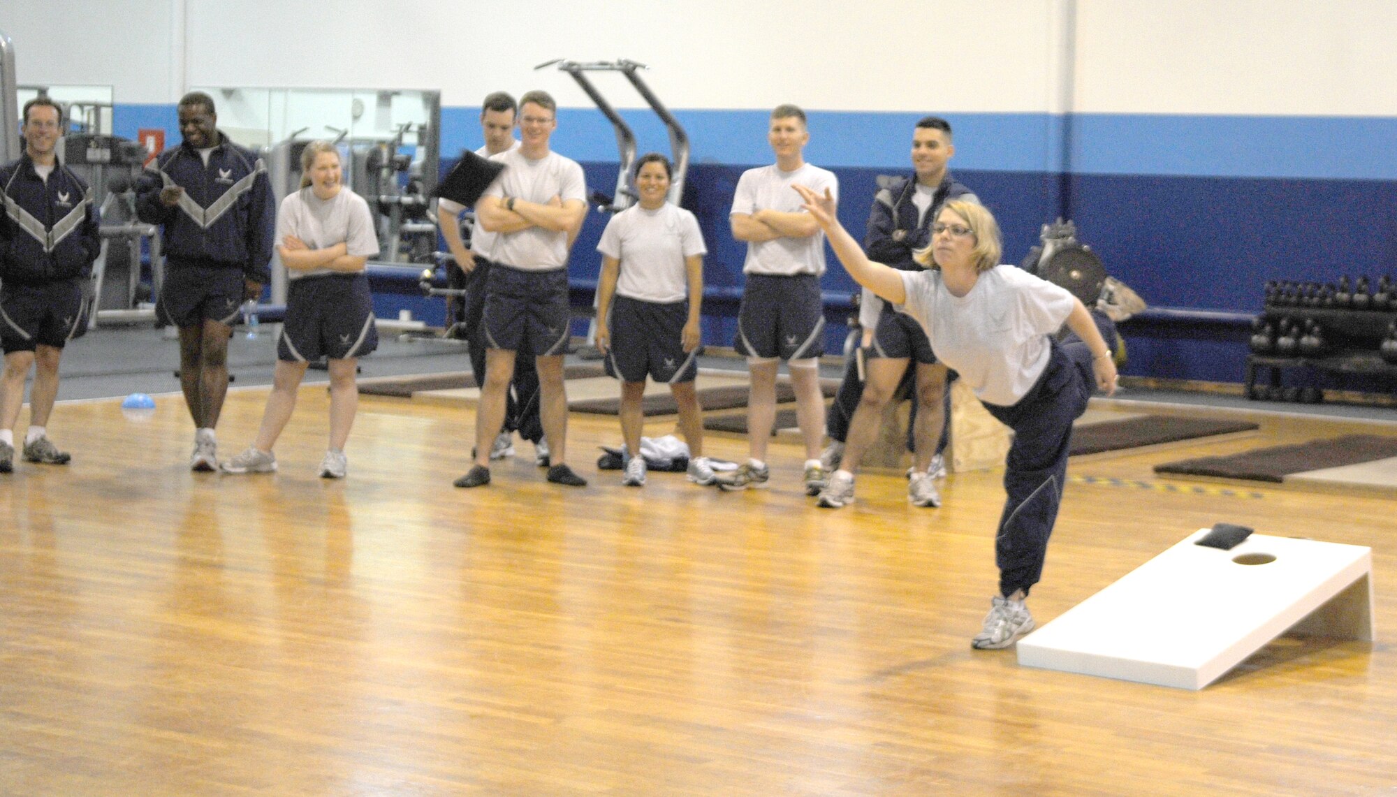 Maj. Joy Primoli, 17th Air Force Judge Advocate, tosses a bean bag in the 17th AF bean bag toss/cornhole competition at the North Side gym during Wingman Day May 26. Wingman Day is an Air Force initiated event to help build the concept of Airmen helping Airmen in times of need as well as helping to build a rapport with one another. Events included motor vehicle safety and suicide awareness. (U.S. Air Force photo by Staff Sgt. Stefanie Torres)