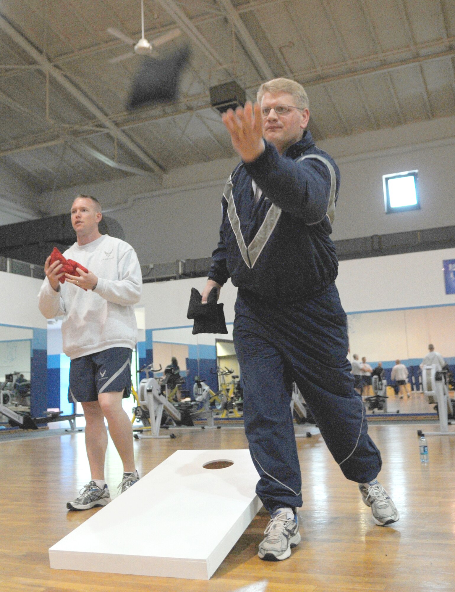Capt. Ryan Murray (left) and Capt. Robert Michael (right) compete in the 17th Air Force bean bag toss/cornhole competition at the North Side gym during Wingman Day May 26. Wingman Day is an Air Force initiated event to help build the concept of Airmen helping Airmen in times of need as well as helping to build a rapport with one another. Capt. Murray is the A4/7 site survey and planning chief. Capt. Michael is the A2 chief of the Intelligence, Surveillance, and Reconnaissance operations branch. (U.S. Air Force photo by Staff Sgt. Stefanie Torres)