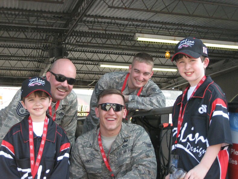 Chad of Chad and Jacob of Racing for Kids share a moment with Master Sgt. Bill Sistler, Staff Sgt. Chandler Boetcher and Senior Airman Joshua. Photo by Mark Meaders, Operation Helmet
