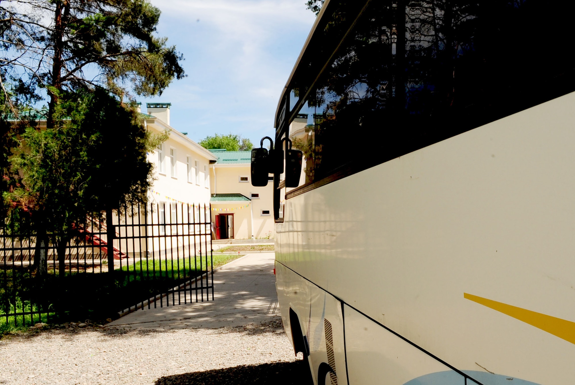 A bus sits outside of the Birdik Village School after Col. Blaine Holt, Transit Center Director, presented it on behalf of the Transit Center at Manas, Kyrgyzstan, May 25, 2010.  Airmen from the Transit Center were invited to attend a graduation ceremony culminating the end of the school year. This year's ceremony was especially important because it was the end of the first school year since the reconstruction of the school. (U.S. Air Force photo/ Senior Airman Nichelle Anderson/ released)